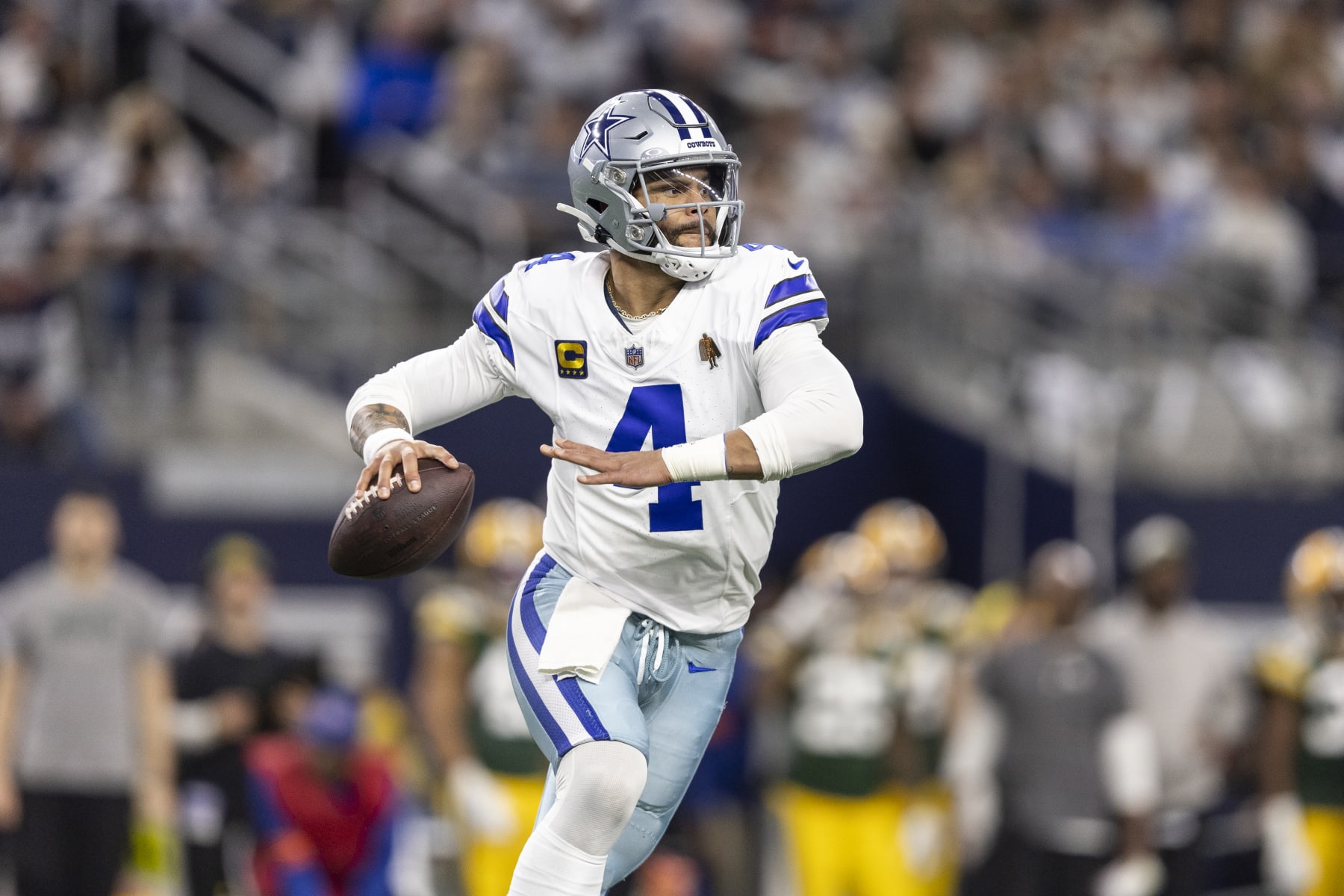 ARLINGTON, TEXAS - JANUARY 14: Dak Prescott #4 of the Dallas Cowboys looks to pass on the run during an NFL wild-card playoff football game between the Dallas Cowboys and the Green Bay Packers at AT&T Stadium on January 14, 2024 in Arlington, Texas. (Photo by Michael Owens/Getty Images)