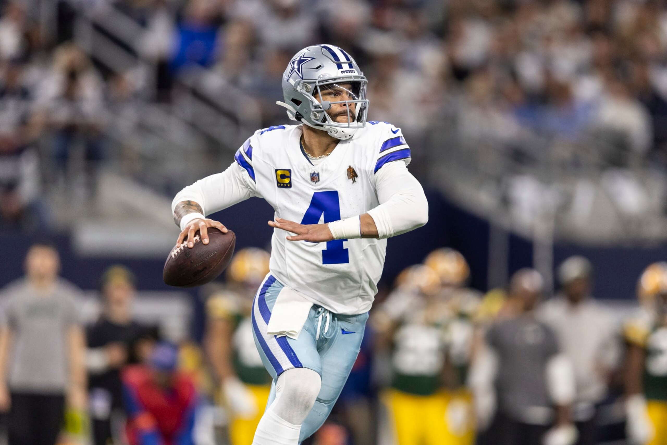 ARLINGTON, TEXAS - JANUARY 14: Dak Prescott #4 of the Dallas Cowboys looks to pass on the run during an NFL wild-card playoff football game between the Dallas Cowboys and the Green Bay Packers at AT&T Stadium on January 14, 2024 in Arlington, Texas. (Photo by Michael Owens/Getty Images)
