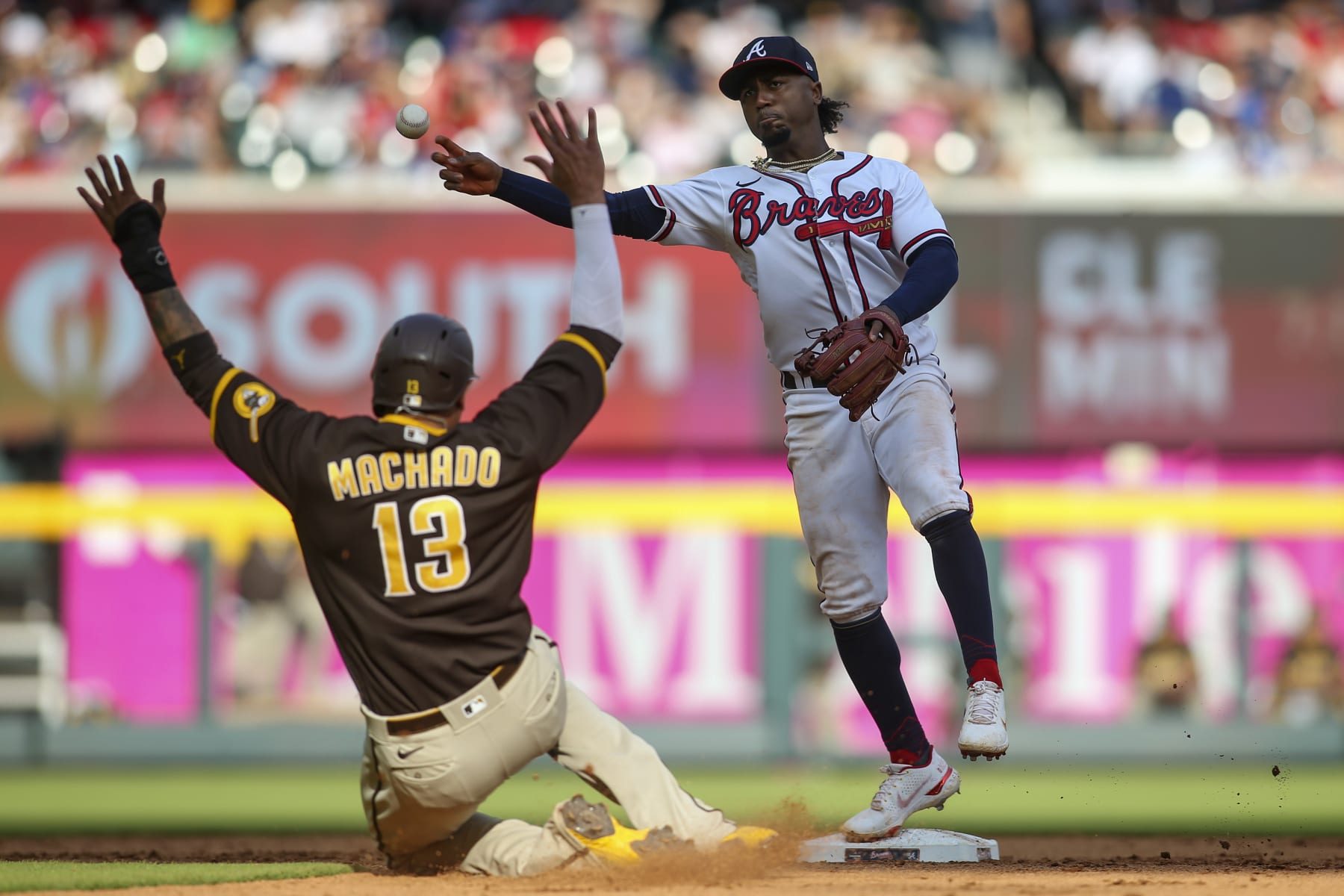ATLANTA, GA - MAY 14: Ozzie Albies #1 of the Atlanta Braves attempts to turn a double play over Manny Machado #13 of the San Diego Padres in the eighth inning of a game at Truist Park on May 14, 2022 in Atlanta, Georgia. (Photo by Brett Davis/Getty Images)