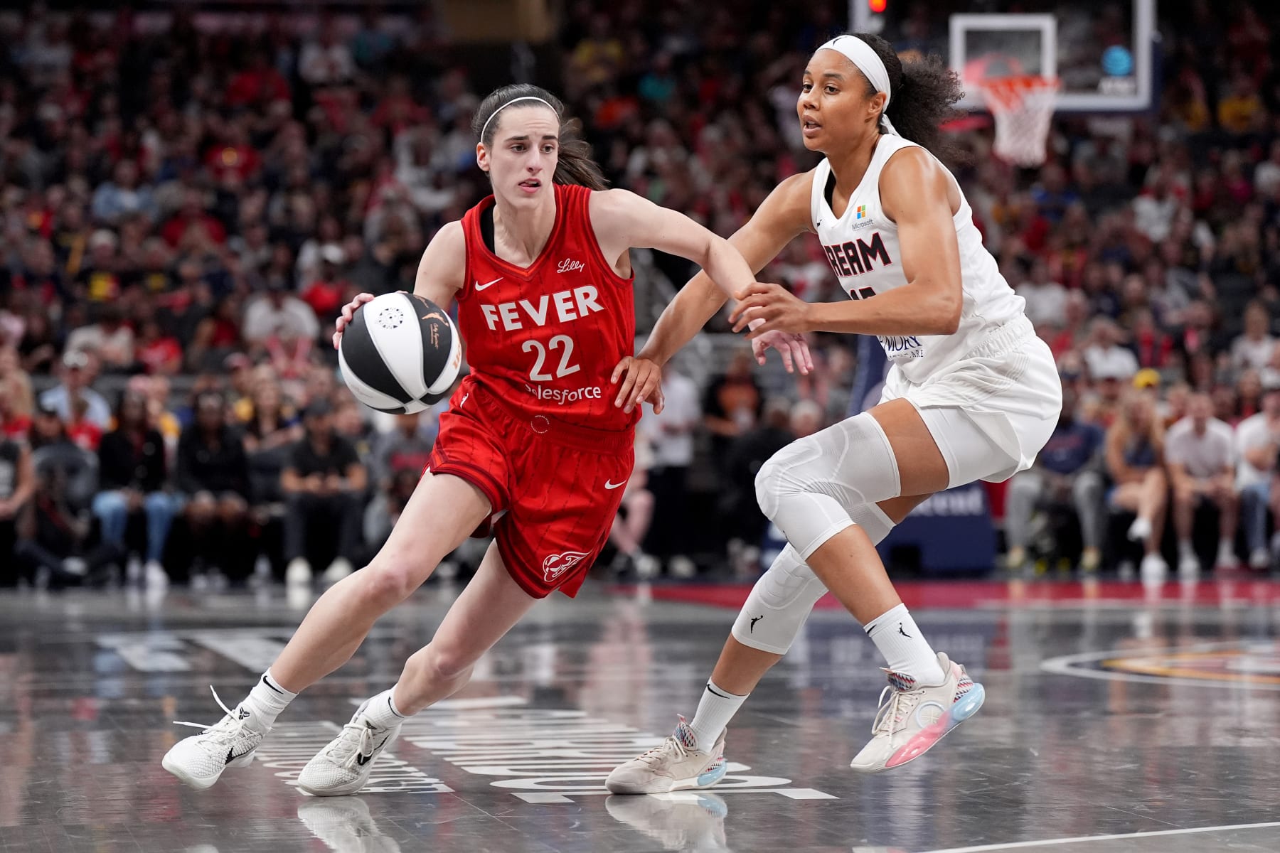 INDIANAPOLIS, INDIANA - JUNE 13: Caitlin Clark #22 of the Indiana Fever dribbles the ball to the basket against Nia Coffey #12 of the Atlanta Dream during the second half at Gainbridge Fieldhouse on June 13, 2024 in Indianapolis, Indiana. NOTE TO USER: User expressly acknowledges and agrees that, by downloading and or using this photograph, User is consenting to the terms and conditions of the Getty Images License Agreement. (Photo by Emilee Chinn/Getty Images)