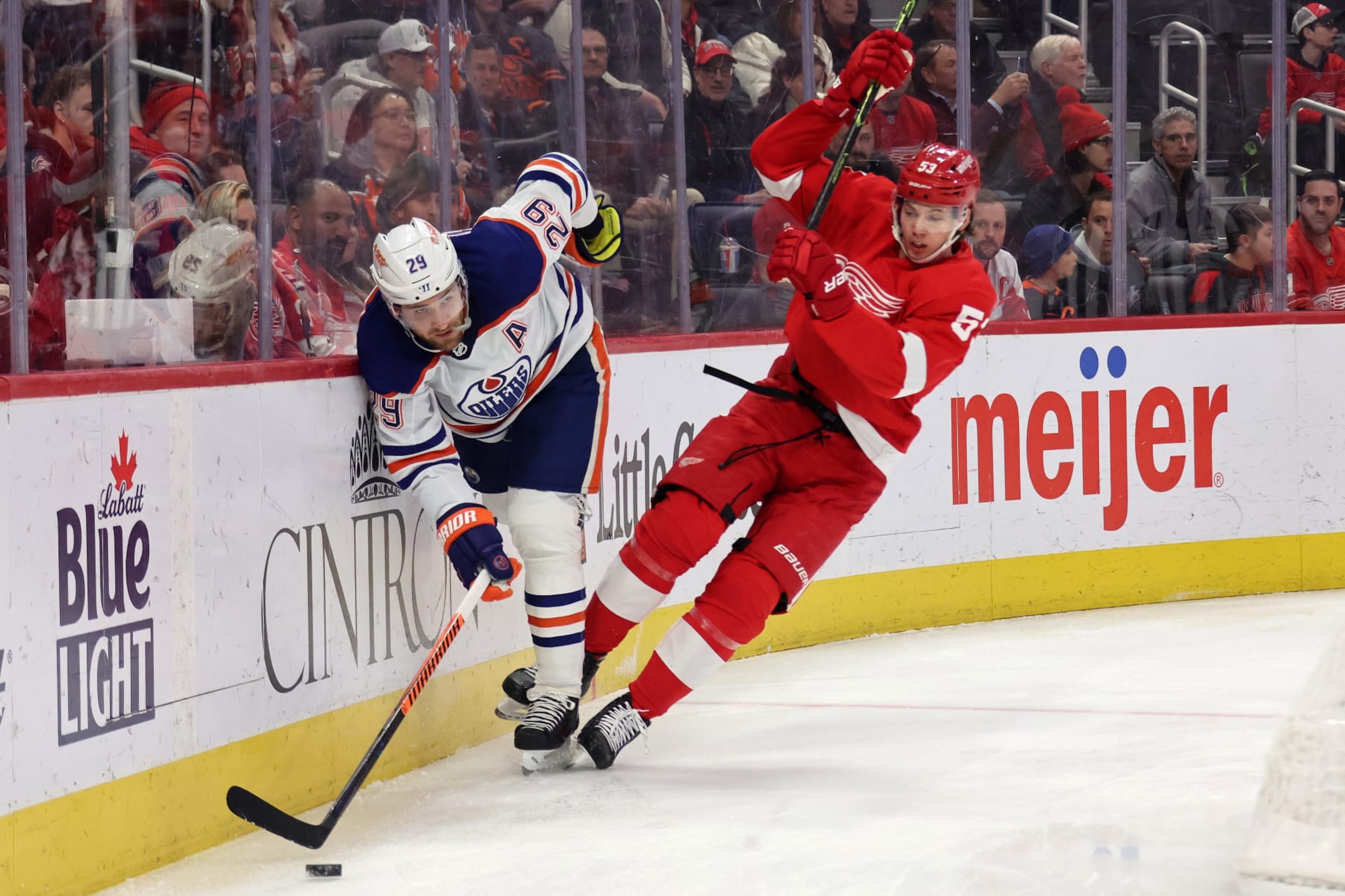 DETROIT, MICHIGAN - FEBRUARY 07:  Leon Draisaitl #29 of the Edmonton Oilers absorbs a hit from Moritz Seider #53 of the Detroit Red Wings during the first period at Little Caesars Arena on February 07, 2023 in Detroit, Michigan. (Photo by Gregory Shamus/Getty Images)