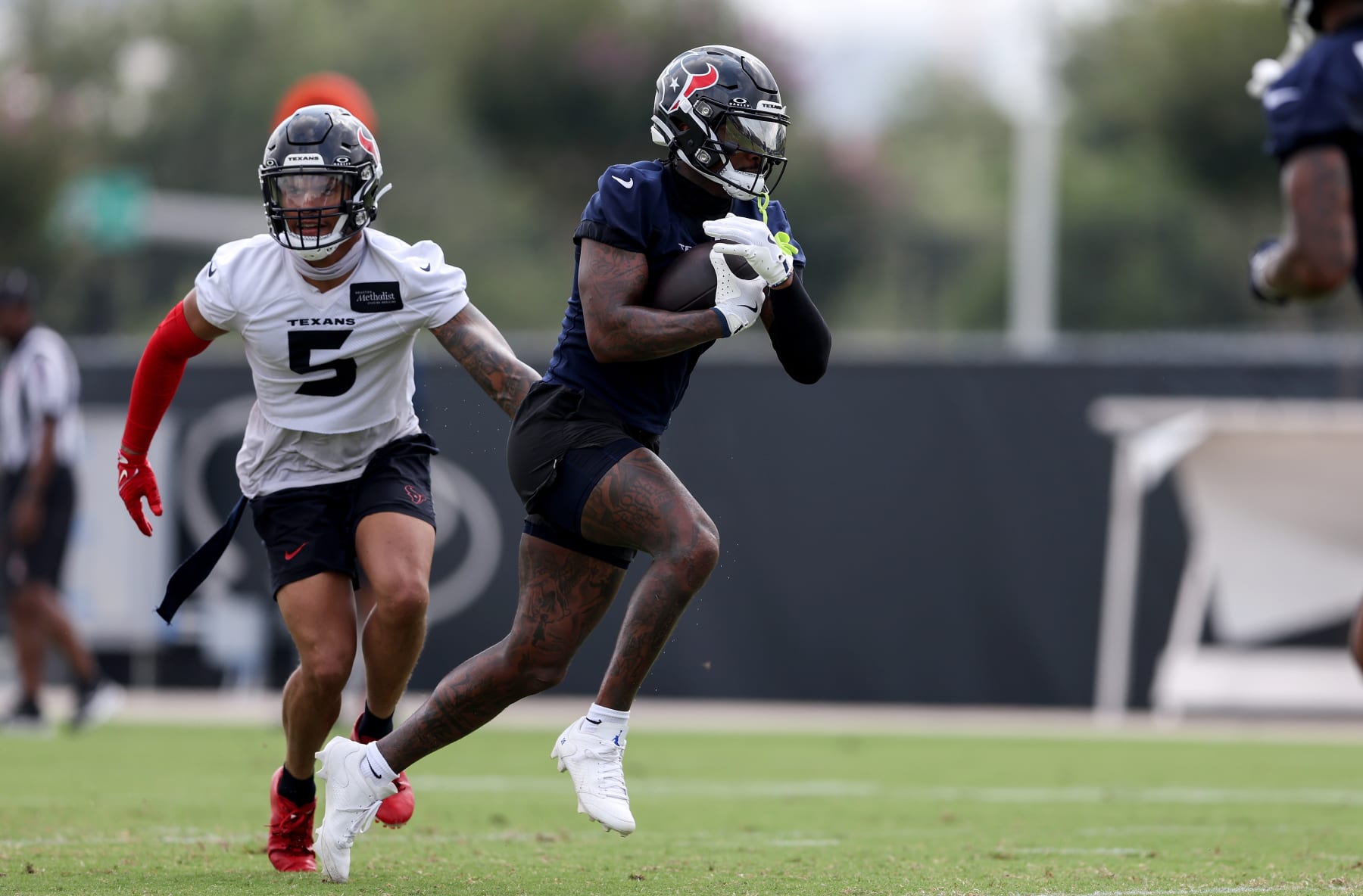 HOUSTON, TEXAS - JUNE 04: Stefon Diggs #1 of the Houston Texans runs after a catch while defended by Jalen Pitre #5 during Mandatory Minicamp at Houston Methodist Training Center on June 04, 2024 in Houston, Texas. (Photo by Tim Warner/Getty Images)