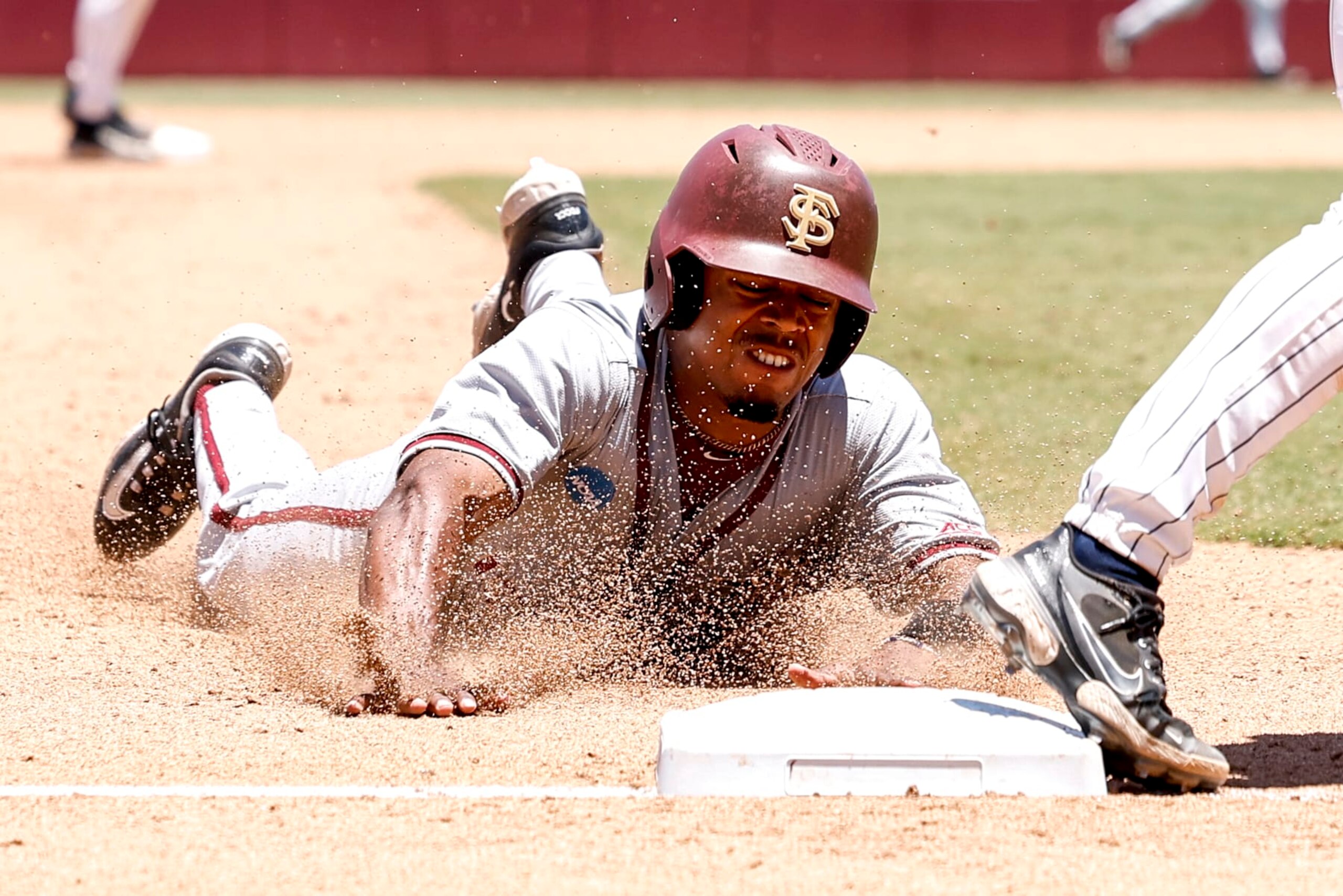 TALLAHASSEE, FL - JUNE 08: Outfielder Jordan Williams #12 of the Florida State Seminoles slides into third base during game 2 against the UConn Huskies in the 2024 NCAA Baseball Super Regional on Mike Martin Field at Dick Howser Stadium on June 8, 2024 in Tallahassee, Florida. The Seminoles defeated the UConn Huskies 10-8 in 12 innings to advance to the College World Series for the 24th time in the program history. (Photo by Don Juan Moore/Getty Images)