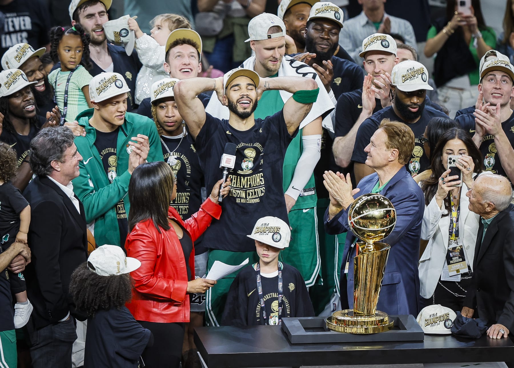 Boston, MA - June 17: Boston Celtics forward Jayson Tatum, with his son Deuce, takes in the moment with the Larry O'Brien Championship Trophy after winning the 2024 NBA Finals. (Photo by Erin Clark/The Boston Globe via Getty Images)