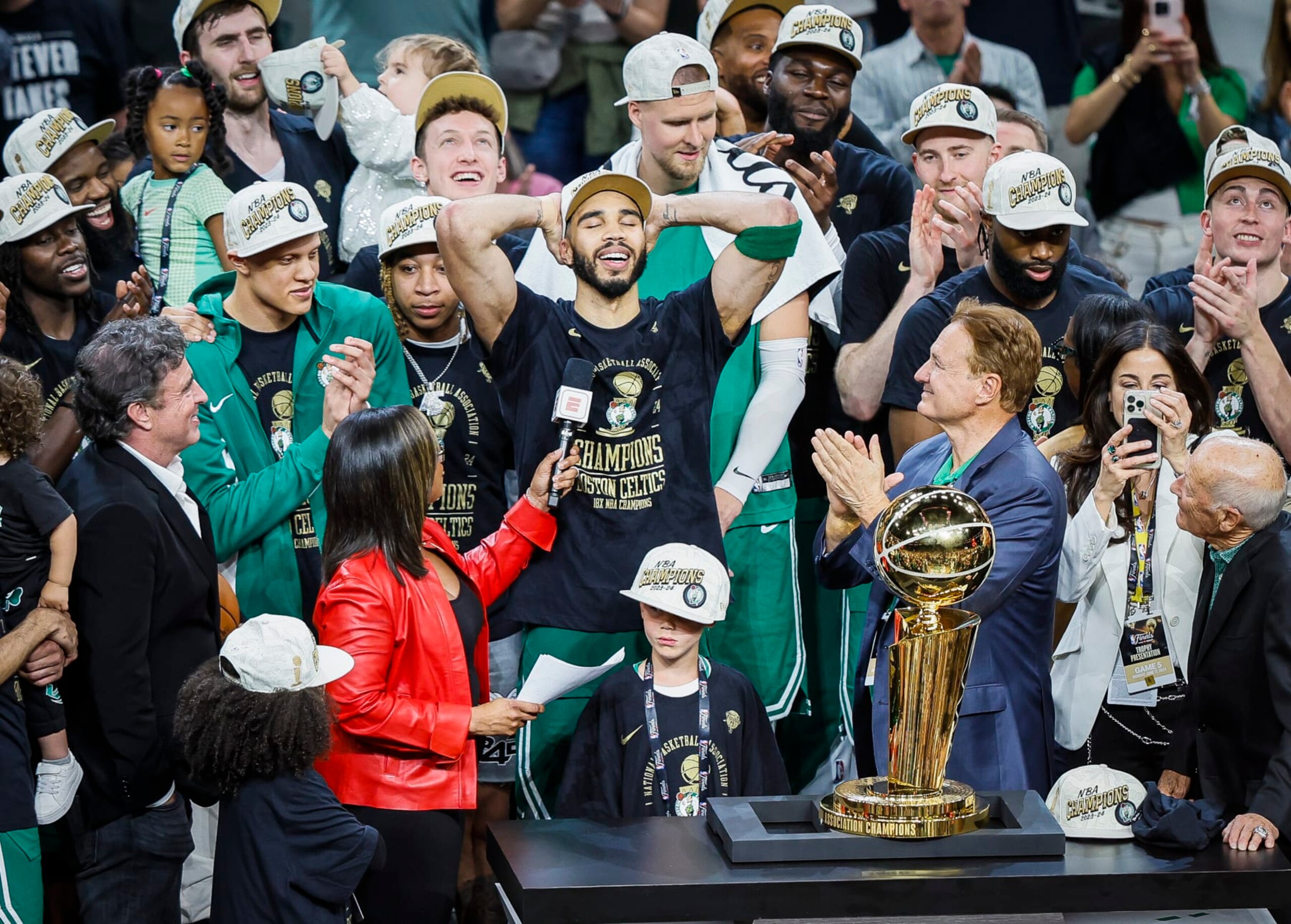 Boston, MA - June 17: Boston Celtics forward Jayson Tatum, with his son Deuce, takes in the moment with the Larry O'Brien Championship Trophy after winning the 2024 NBA Finals. (Photo by Erin Clark/The Boston Globe via Getty Images)