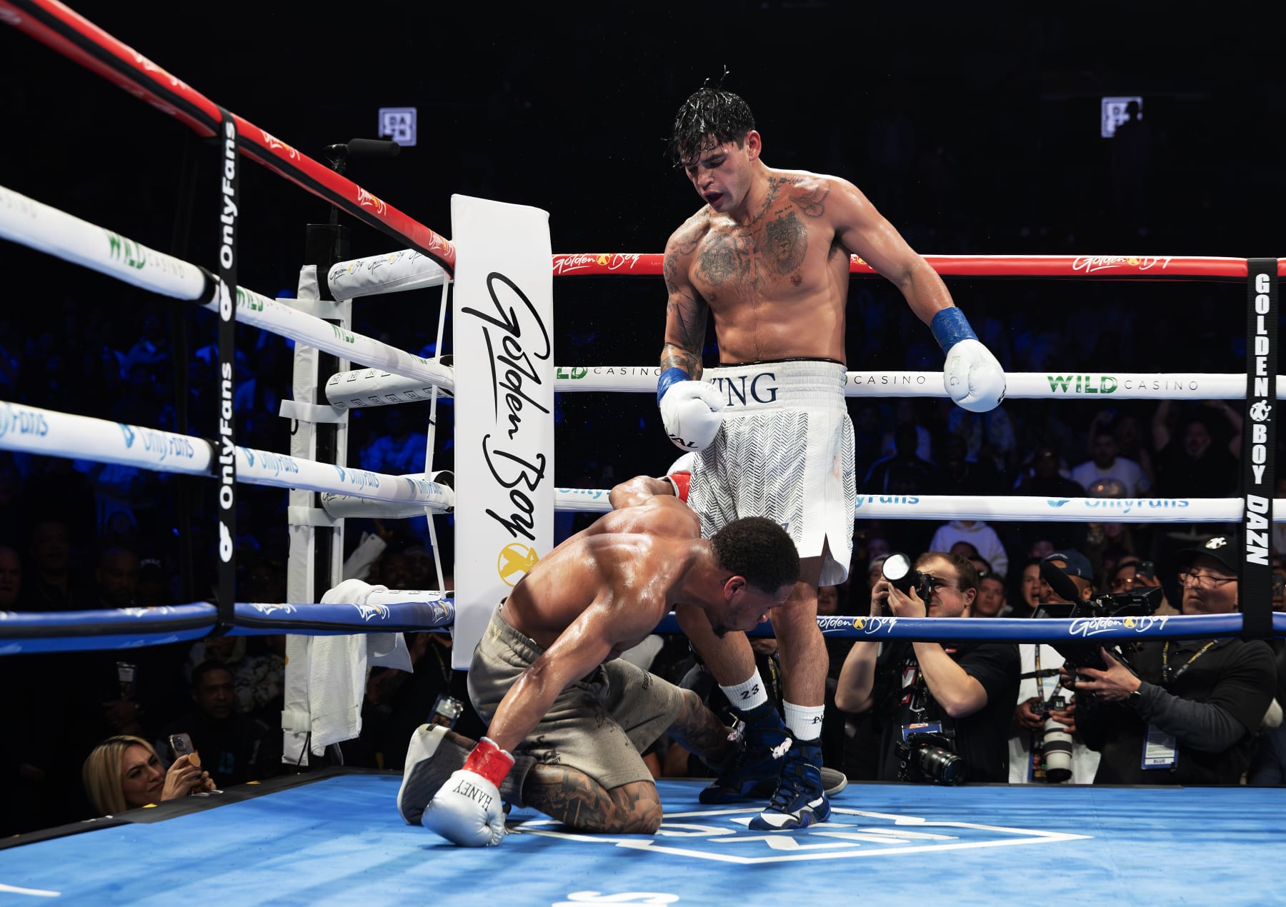 NEW YORK, NEW YORK - APRIL 20:   Ryan Garcia (white trunks) knocks down Devin Haney (gray trunks) during their WBC Super Lightweight title bout at Barclays Center on April 20, 2024 in New York City. (Photo by Al Bello/Getty Images)