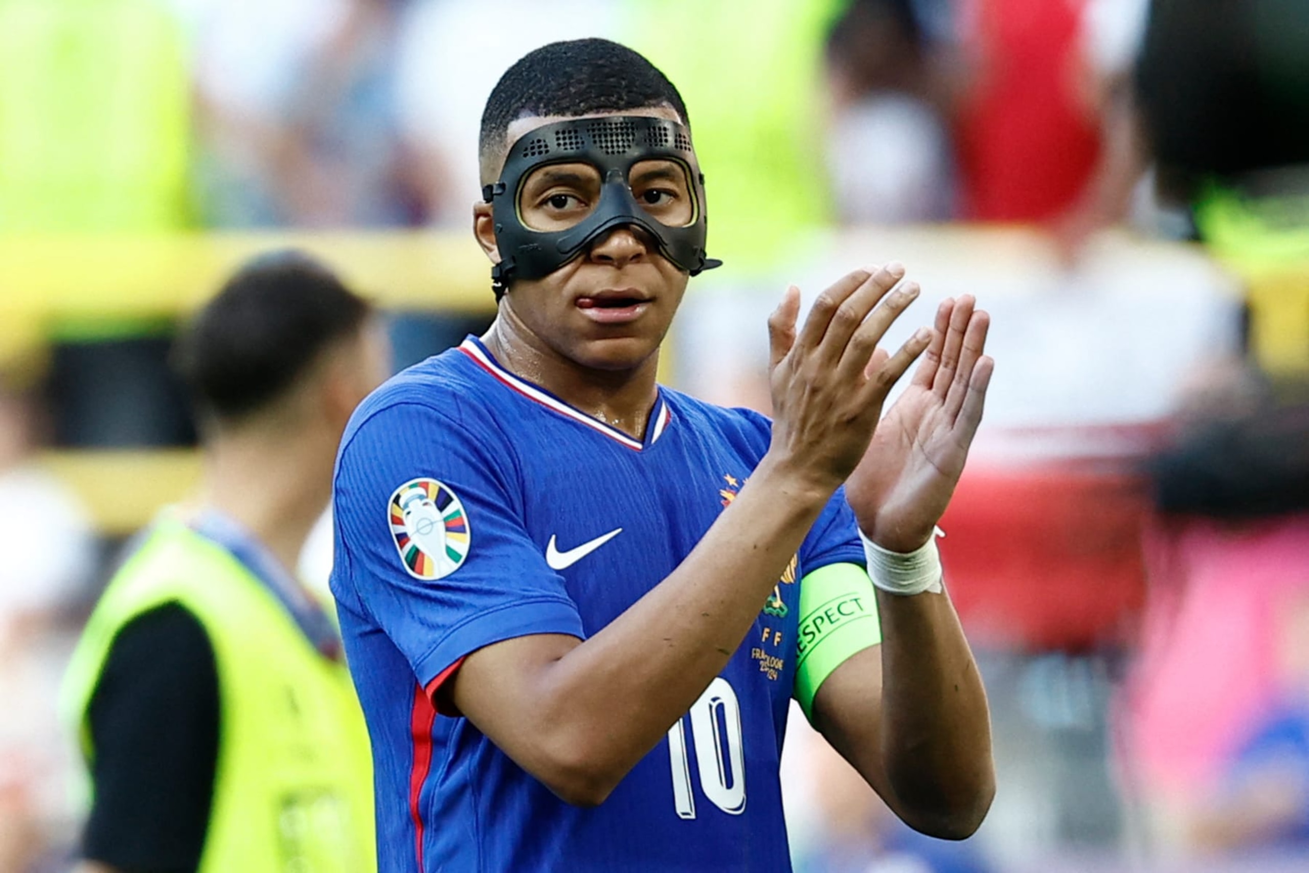 France's forward #10 Kylian Mbappe, wearing a protective mask, applauds after the UEFA Euro 2024 Group D football match between France and Poland at the BVB Stadion in Dortmund on June 25, 2024. (Photo by KENZO TRIBOUILLARD / AFP) (Photo by KENZO TRIBOUILLARD/AFP via Getty Images) France's forward #10 Kylian Mbappe, wearing a protective mask, applauds after the UEFA Euro 2024 Group D football match between France and Poland at the BVB Stadion in Dortmund on June 25, 2024. (Photo by KENZO TRIBOUILLARD / AFP) (Photo by KENZO TRIBOUILLARD/AFP via Getty Images)