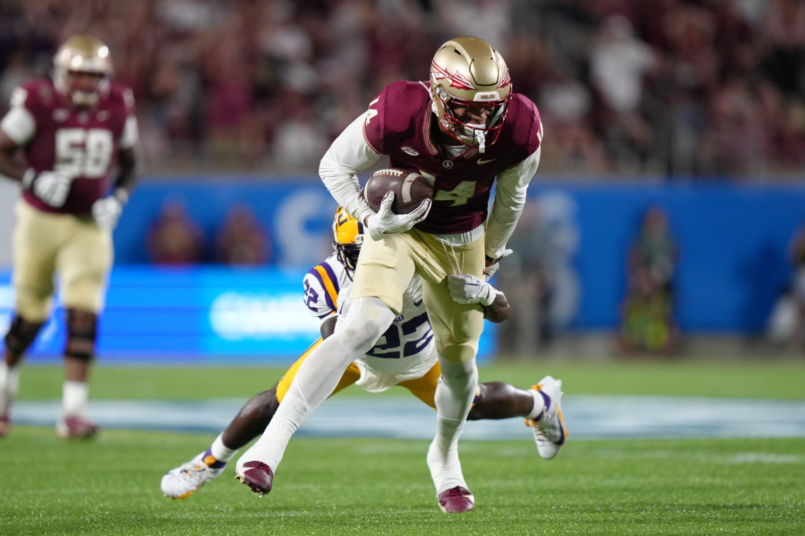 ORLANDO, FL - SEPTEMBER 03: Florida State Seminoles wide receiver Johnny Wilson (14) tries to fight off a tackle attempt by LSU Tigers cornerback Duce Chestnut (22) during the Camping World Kickoff game between the LSU Tigers and the Florida State Seminoles, on Sunday, September 3, 2023 at Camping World Stadium in Orlando, Fla. (Photo by Peter Joneleit/Icon Sportswire via Getty Images)