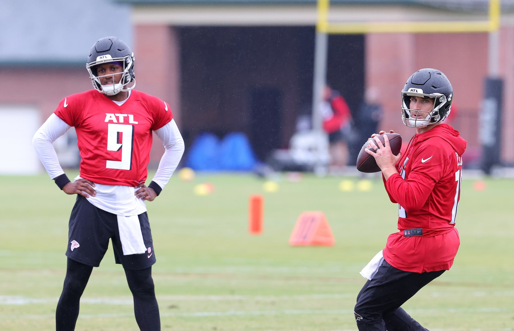 FLOWERY BRANCH, GEORGIA - MAY 14:  Quarterback Kirk Cousins #18 of the Atlanta Falcons looks to pass as quarterback Michael Penix Jr. #9 looks on during OTA offseason workouts at the Atlanta Falcons training facility on May 14, 2024 in Flowery Branch, Georgia. (Photo by Kevin C. Cox/Getty Images)