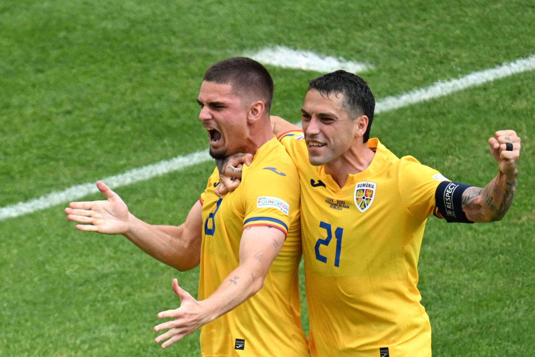 Romania's midfielder #18 Razvan Marin (L)  celebrates with Romania's midfielder #21 Nicolae Stanciu  after scoring a penalty kick for his team's first goal during the UEFA Euro 2024 Group E football match between Slovakia and Romania at the Frankfurt Arena in Frankfurt am Main on June 26, 2024. (Photo by Kirill KUDRYAVTSEV / AFP) (Photo by KIRILL KUDRYAVTSEV/AFP via Getty Images)
