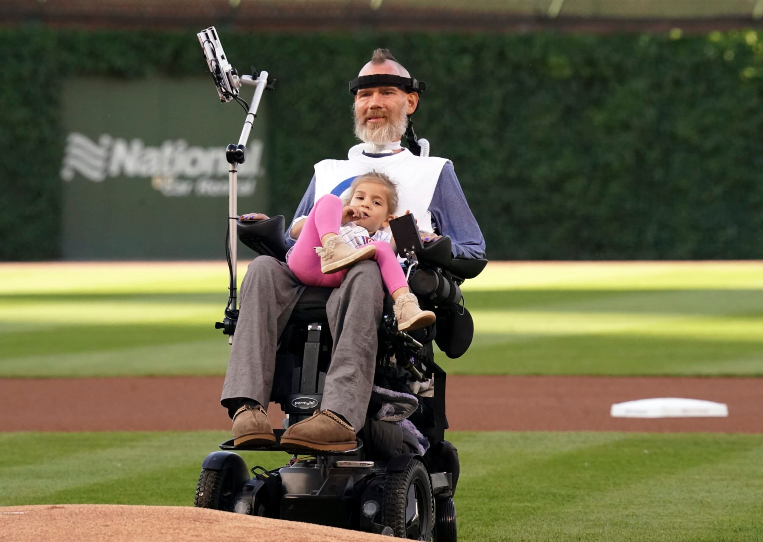 CHICAGO, ILLINOIS - JUNE 02:  Steve Gleason, a sufferer of Amyotrophic Lateral Sclerosis (ALS), holds his daughter Gray, 3 while watching his son Rivers throws the ceremonial first pitch of the game between the Chicago Cubs and the St. Louis Cardinals at Wrigley Field on June 02, 2022 in Chicago, Illinois. (Photo by Nuccio DiNuzzo/Getty Images)