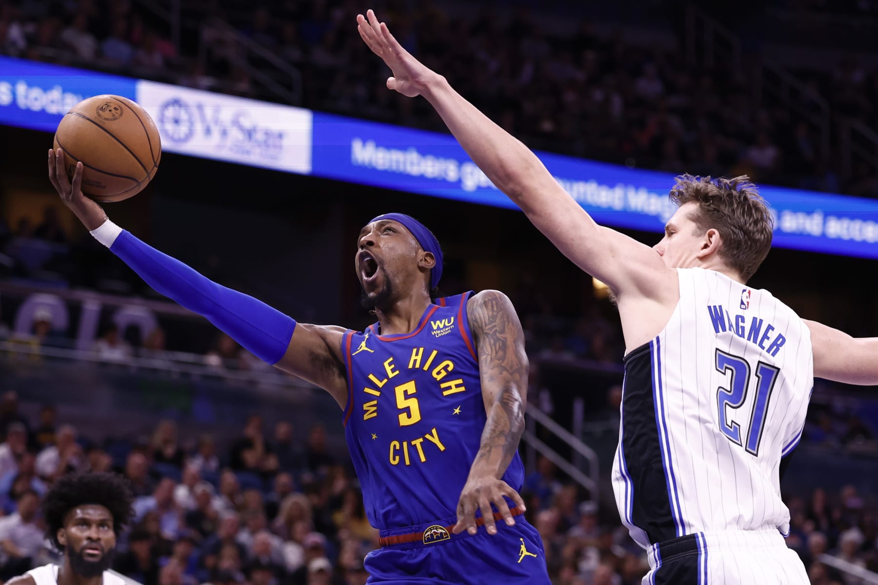 ORLANDO, FLORIDA - FEBRUARY 09: Kentavious Caldwell-Pope #5 of the Denver Nuggets drives to the net as Moritz Wagner #21 of the Orlando Magic defends during the first quarter at Amway Center on February 09, 2023 in Orlando, Florida. NOTE TO USER: User expressly acknowledges and agrees that, by downloading and or using this photograph, User is consenting to the terms and conditions of the Getty Images License Agreement. (Photo by Douglas P. DeFelice/Getty Images)