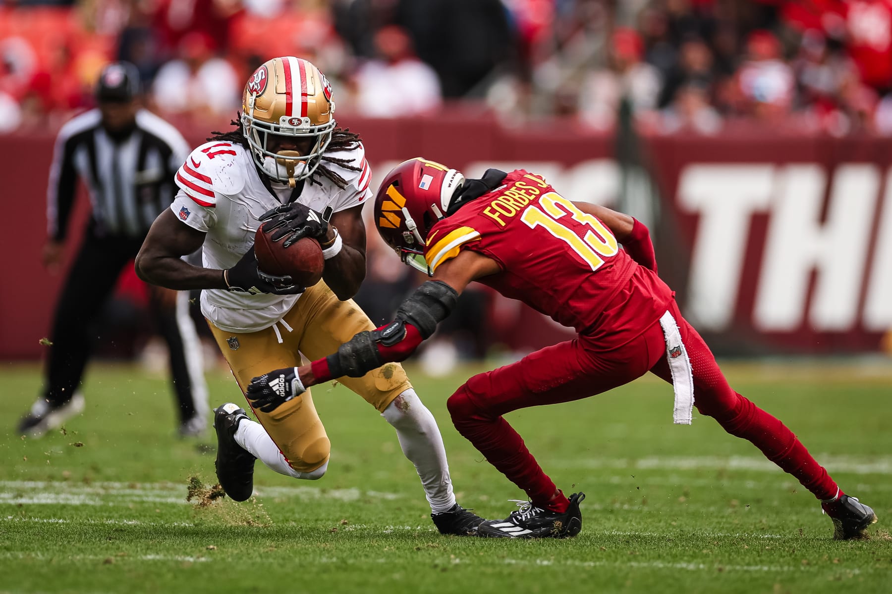 LANDOVER, MD - DECEMBER 31: Brandon Aiyuk #11 of the San Francisco 49ers runs with the ball against Emmanuel Forbes #13 of the Washington Commanders during the second half of the game at FedExField on December 31, 2023 in Landover, Maryland. (Photo by Scott Taetsch/Getty Images)