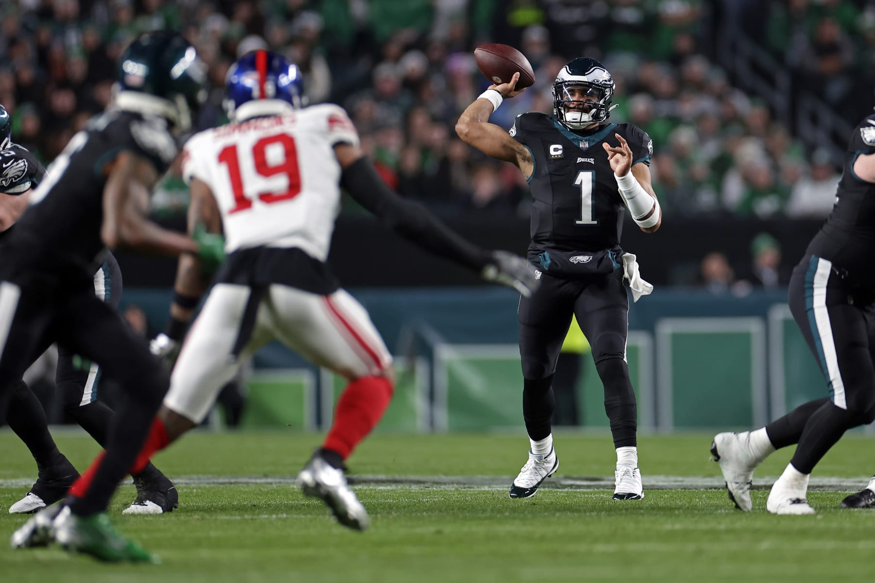 PHILADELPHIA, PENNSYLVANIA - DECEMBER 25: Jalen Hurts #1 of the Philadelphia Eagles passes to DeVonta Smith #6 of the Philadelphia Eagles behind Isaiah Simmons #19 of the New York Giants at Lincoln Financial Field on December 25, 2023 in Philadelphia, Pennsylvania. (Photo by Adam Hunger/Getty Images)