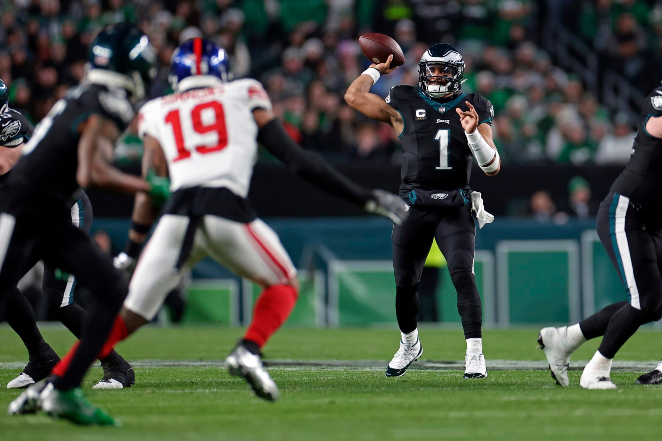 PHILADELPHIA, PENNSYLVANIA - DECEMBER 25: Jalen Hurts #1 of the Philadelphia Eagles passes to DeVonta Smith #6 of the Philadelphia Eagles behind Isaiah Simmons #19 of the New York Giants at Lincoln Financial Field on December 25, 2023 in Philadelphia, Pennsylvania. (Photo by Adam Hunger/Getty Images)