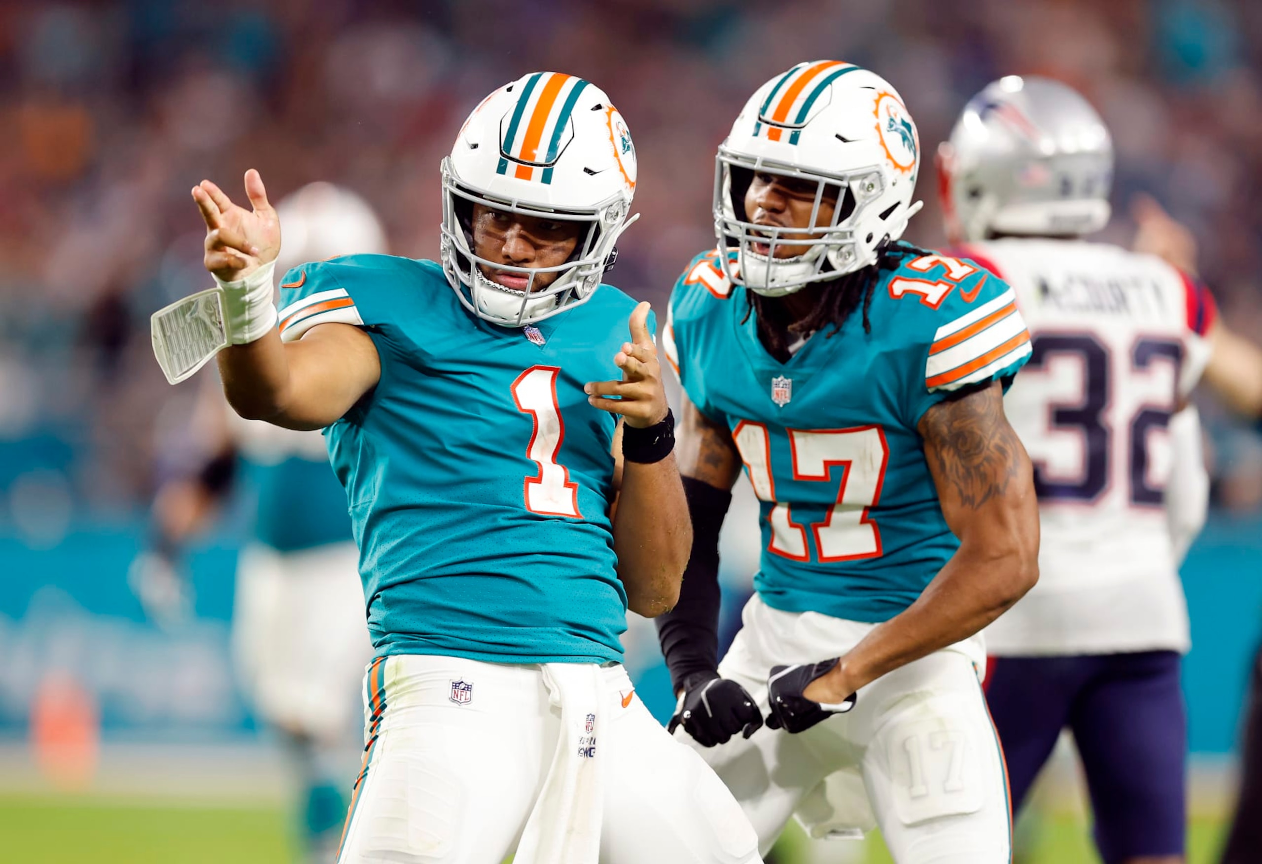 MIAMI GARDENS, FLORIDA - JANUARY 09: Tua Tagovailoa #1 of the Miami Dolphins and Jaylen Waddle #17 celebrate a first down in the fourth quarter of the game against the New England Patriots at Hard Rock Stadium on January 09, 2022 in Miami Gardens, Florida. (Photo by Michael Reaves/Getty Images)