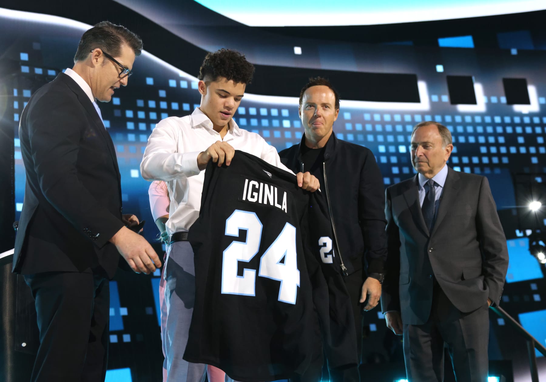 LAS VEGAS, NEVADA - JUNE 28: Tij Iginla puts on a jersey after being selected sixth overall by Utah Hockey Club during the first round of the 2024 Upper Deck NHL Draft at Sphere on June 28, 2024 in Las Vegas, Nevada. (Photo by Dave Sandford/NHLI via Getty Images)