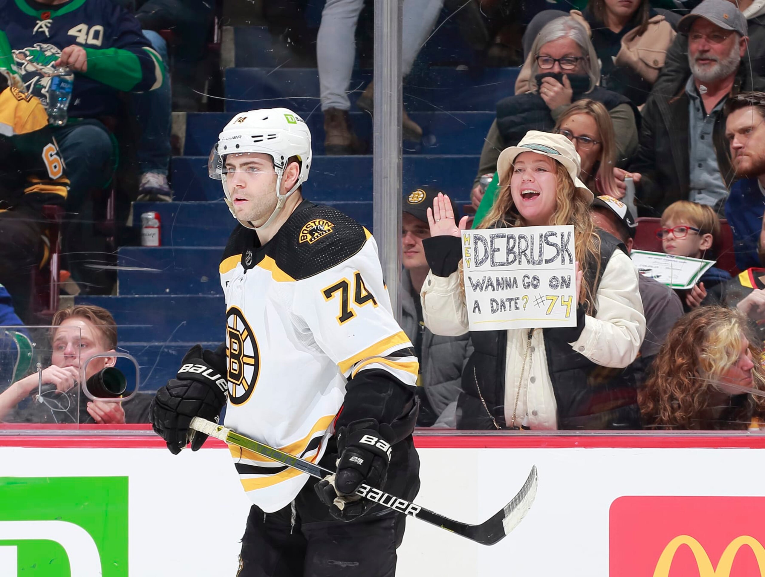 VANCOUVER, CANADA - FEBRUARY 25: Jake DeBrusk #74 of the Boston Bruins skates by fan holding up a date request during the second period of their NHL game against the Vancouver Canucks at Rogers Arena February 25, 2023 in Vancouver, British Columbia, Canada. (Photo by Jeff Vinnick/NHLI via Getty Images) VANCOUVER, CANADA - FEBRUARY 25: Jake DeBrusk #74 of the Boston Bruins skates by fan holding up a date request during the second period of their NHL game against the Vancouver Canucks at Rogers Arena February 25, 2023 in Vancouver, British Columbia, Canada. (Photo by Jeff Vinnick/NHLI via Getty Images)