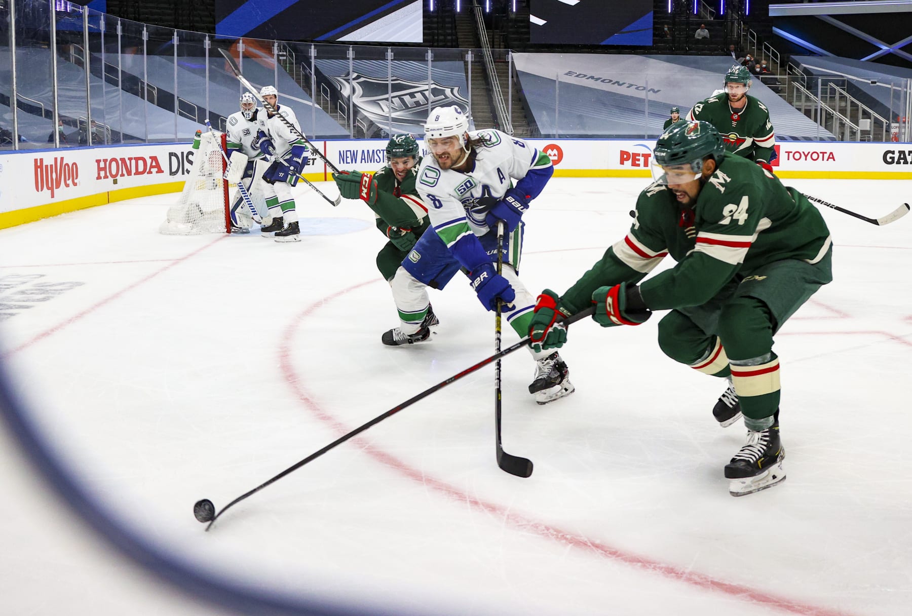 EDMONTON, ALBERTA - AUGUST 06: Matt Dumba #24 of the Minnesota Wild battles for the puck against Chris Tanev #8 of the Vancouver Canucks during the third in Game Three of the Western Conference Qualification Round at Rogers Place on August 06, 2020 in Edmonton, Alberta. (Photo by Dave Sandford/NHLI via Getty Images)
