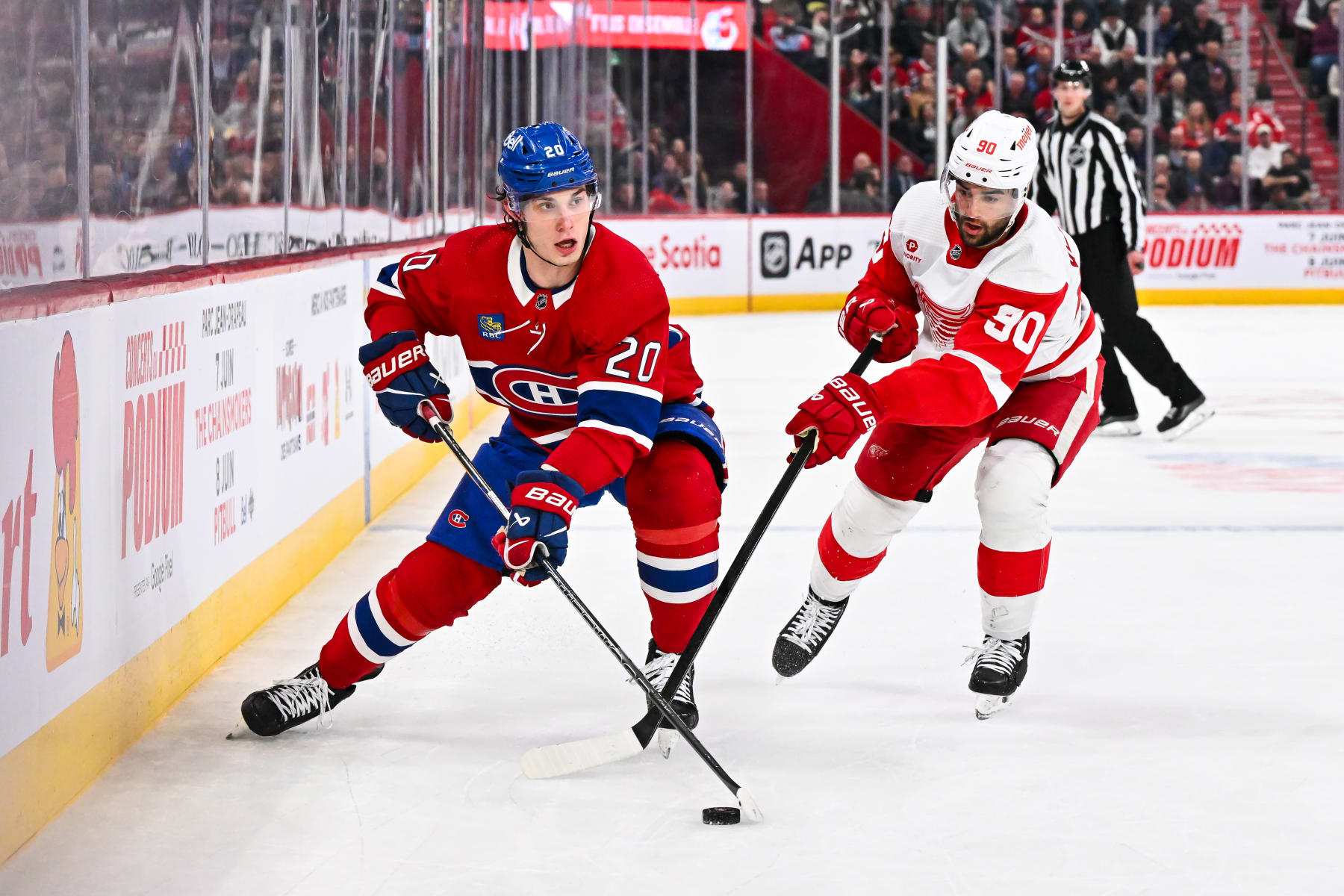 MONTREAL, CANADA - APRIL 16:  Juraj Slafkovsky #20 of the Montreal Canadiens skates the puck against Joe Veleno #90 of the Detroit Red Wings during the second period at the Bell Centre on April 16, 2024 in Montreal, Quebec, Canada.  (Photo by Minas Panagiotakis/Getty Images)