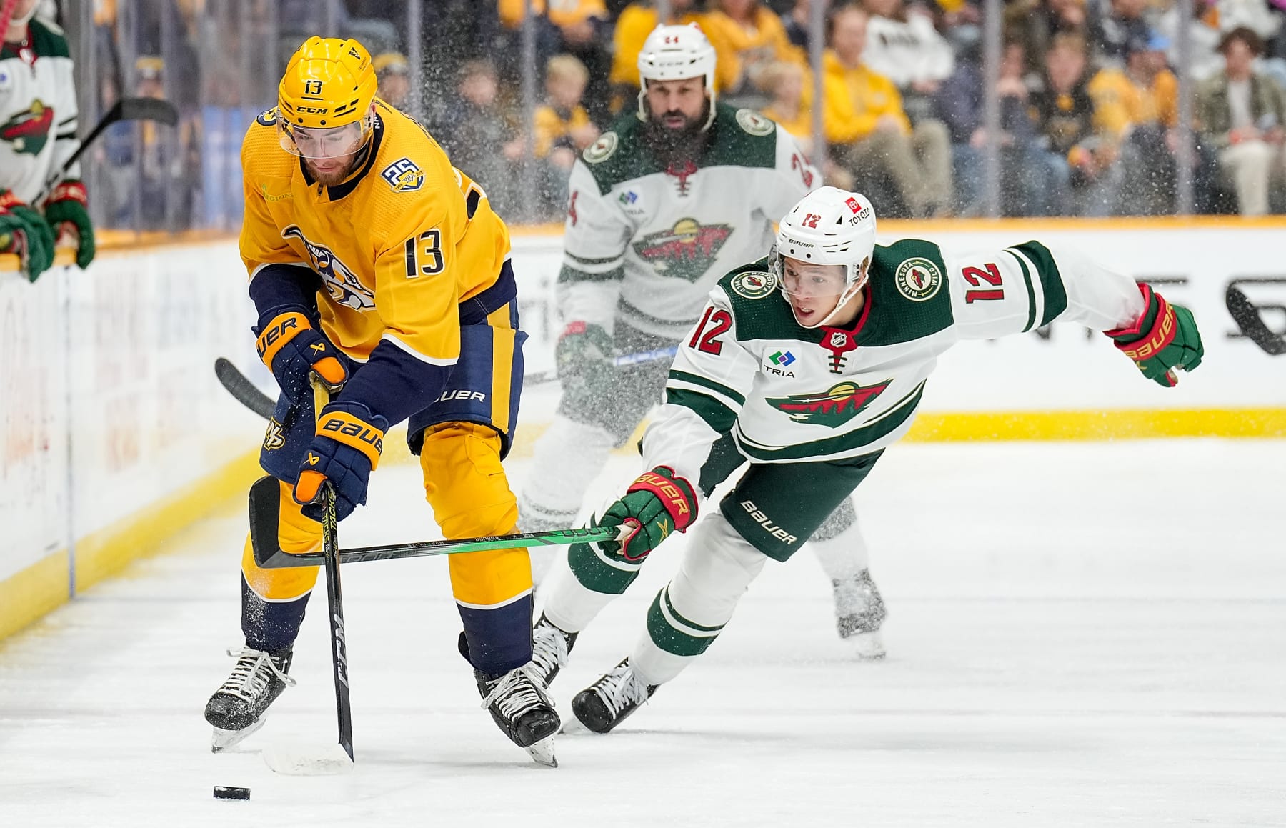 NASHVILLE, TENNESSEE - NOVEMBER 30: Yakov Trenin #13 of the Nashville Predators skates against Matt Boldy #12 of the Minnesota Wild during an NHL game at Bridgestone Arena on November 30, 2023 in Nashville, Tennessee. (Photo by John Russell/NHLI via Getty Images)