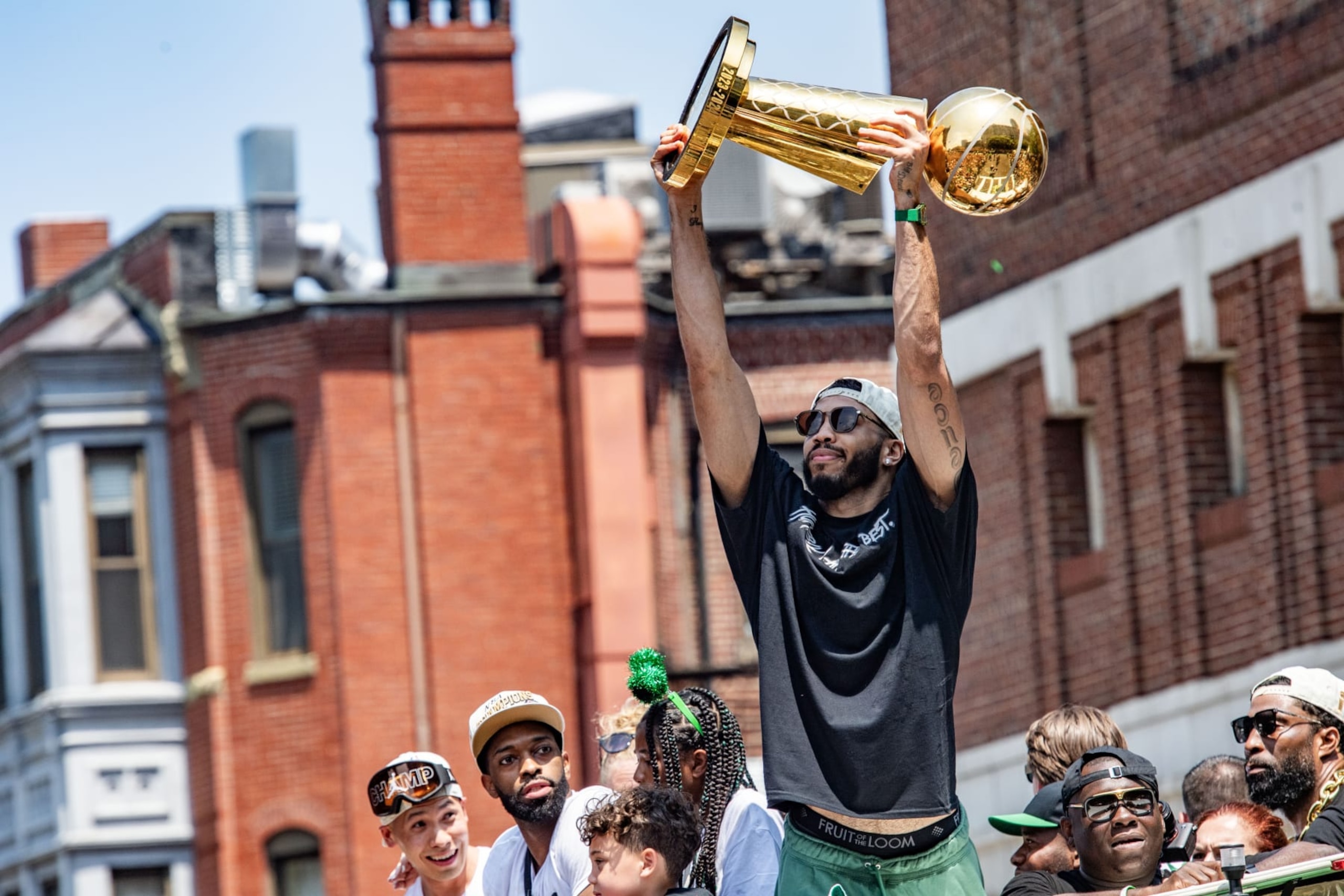 BOSTON, USA - JUNE 21:  Jayson Tatum holds up the Larry O'Brien Championship Trophy as he cheers fans on as he and his teammates celebrate the Celtics team winning the 2024 NBA Championship during a parade through the streets in duck boats in Boston, Massachusetts on June 21, 2024. (Photo by Joseph Prezioso/Anadolu via Getty Images)