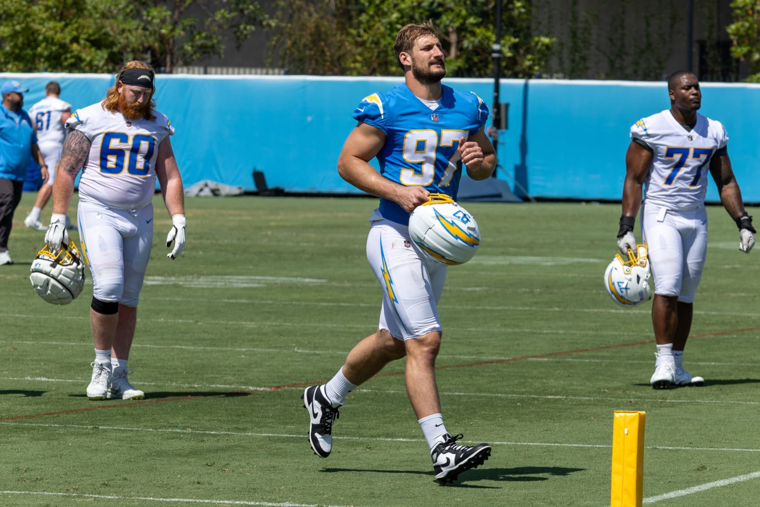 Costa Mesa, CA - June 13: Chargers center/guard Bucky Williams, left, #60, outside linebacker Joey Bosa, #97, center, and guard Zion Johnson, right, walk off the field during the Chargers mini camp at Hoag Performance Center in Costa Mesa Thursday, June 13, 2024. (Allen J. Schaben / Los Angeles Times via Getty Images)