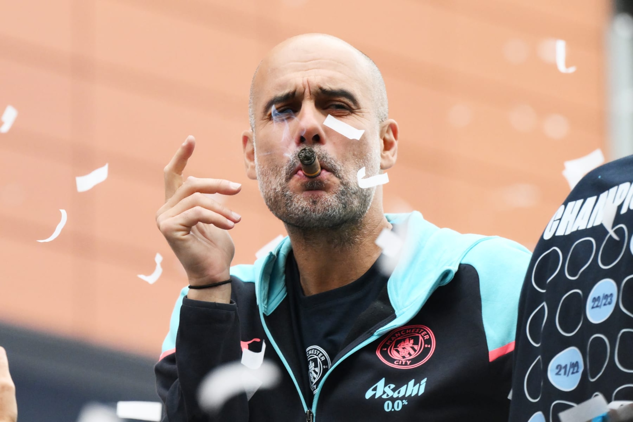 MANCHESTER, ENGLAND - MAY 26: Pep Guardiola, Manager of Manchester City, looks on as he smokes a cigar whilst on the Open Top Bus during the Manchester City trophy parade on May 26, 2024 in Manchester, England. (Photo by Ben Roberts Photo/Getty Images) MANCHESTER, ENGLAND - MAY 26: Pep Guardiola, Manager of Manchester City, looks on as he smokes a cigar whilst on the Open Top Bus during the Manchester City trophy parade on May 26, 2024 in Manchester, England. (Photo by Ben Roberts Photo/Getty Images)