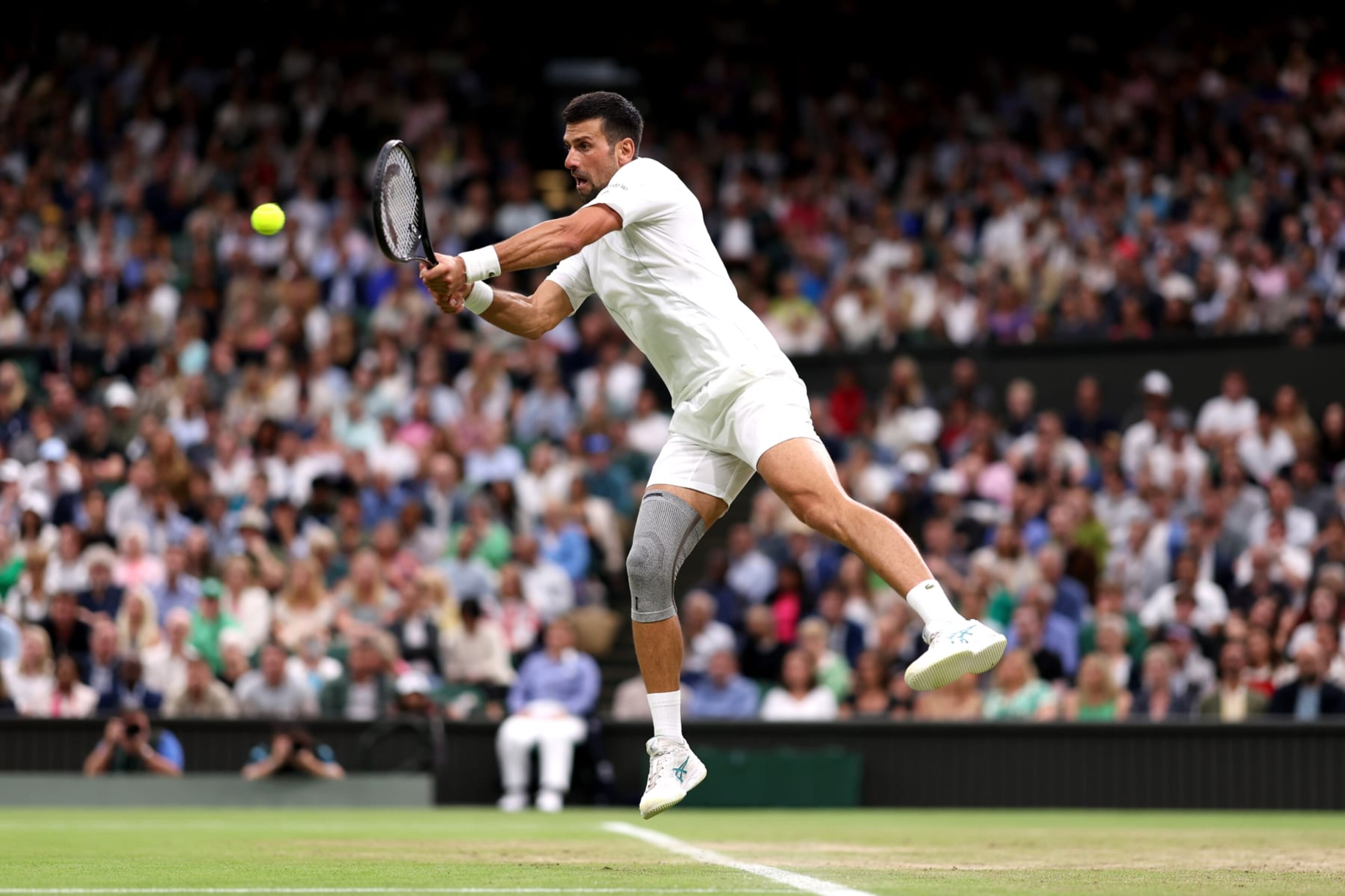 LONDON, ENGLAND - JULY 08: Novak Djokovic of Serbia plays a backhand against Holger Rune of Denmark in his Gentlemen's Singles fourth round match during day eight of The Championships Wimbledon 2024 at All England Lawn Tennis and Croquet Club on July 08, 2024 in London, England. (Photo by Julian Finney/Getty Images) LONDON, ENGLAND - JULY 08: Novak Djokovic of Serbia plays a backhand against Holger Rune of Denmark in his Gentlemen's Singles fourth round match during day eight of The Championships Wimbledon 2024 at All England Lawn Tennis and Croquet Club on July 08, 2024 in London, England. (Photo by Julian Finney/Getty Images)