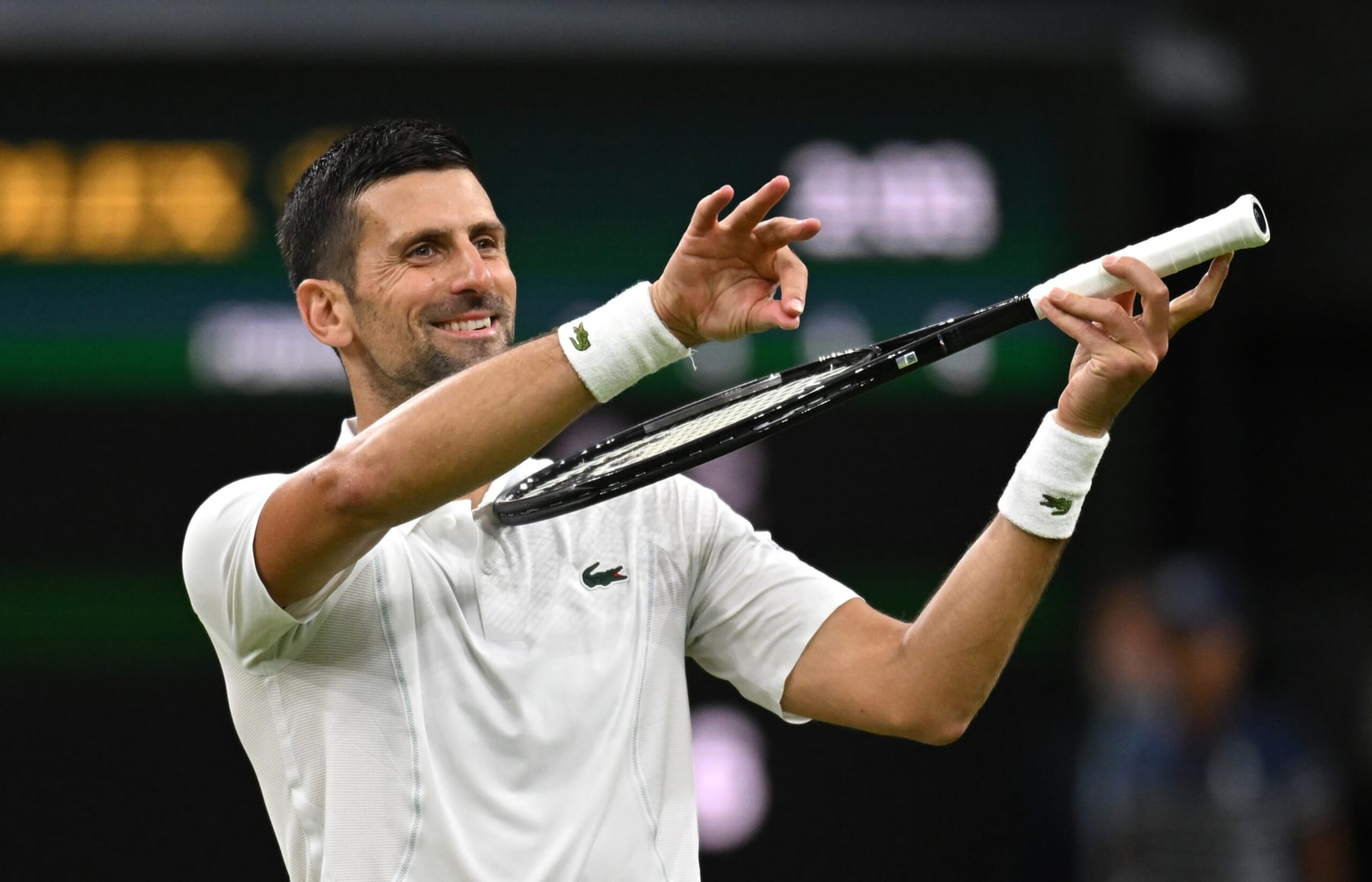 LONDON, ENGLAND - JULY 08: Novak Djokovic of Serbia celebrates winning match point with a violin gesture against Holger Rune of Denmark in his Gentlemen's Singles fourth round match during day eight of The Championships Wimbledon 2024 at All England Lawn Tennis and Croquet Club on July 08, 2024 in London, England. (Photo by Mike Hewitt/Getty Images)