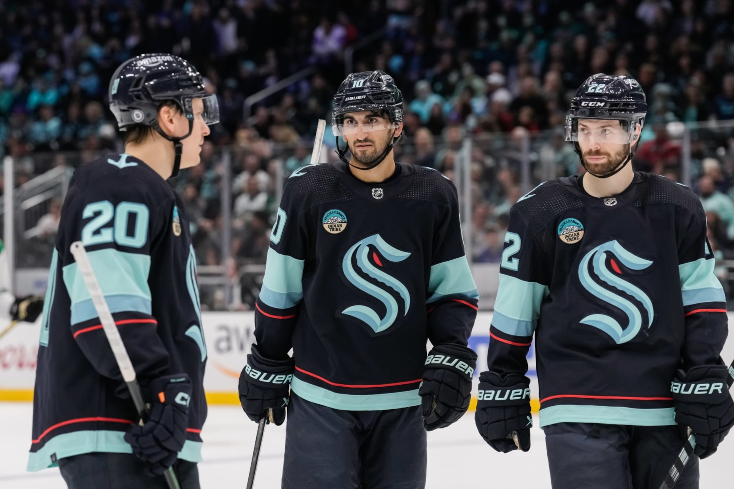 SEATTLE, WASHINGTON - MARCH 30: Eeli Tolvanen #20, Matty Beniers #10 and Oliver Bjorkstrand #22 of the Seattle Kraken talk before a face-off during the second period of a game against the Dallas Stars at Climate Pledge Arena on March 30, 2024 in Seattle, Washington. (Photo by Christopher Mast/NHLI via Getty Images)
