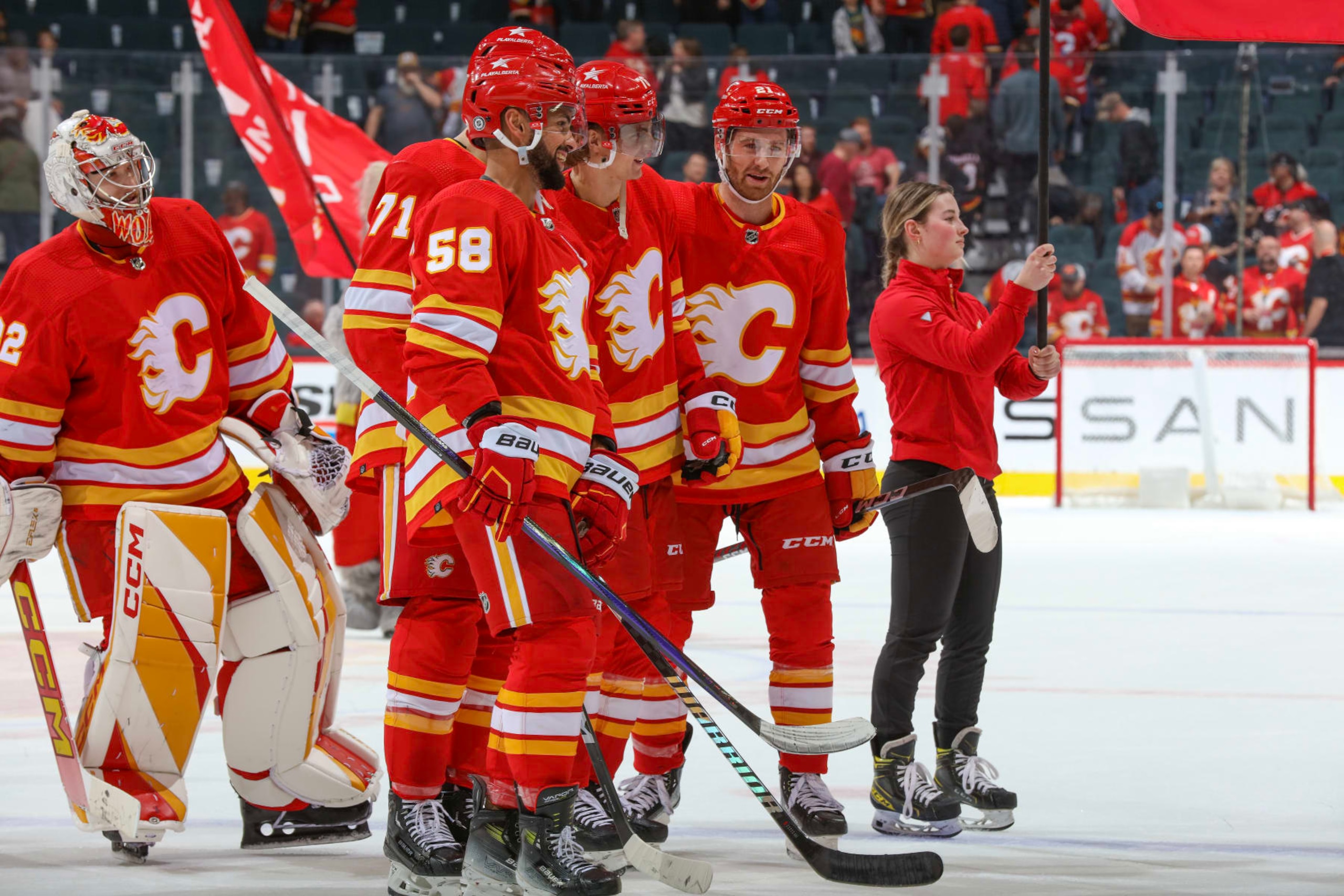 CALGARY, ALBERTA - APRIL 14: Dustin Wolf #32, Oliver Kylington #58 and teammates of the Calgary Flames celebrate a win against the Arizona Coyotes at the Scotiabank Saddledome on April 14, 2024 in Calgary, Alberta. (Photo by Gerry Thomas/NHLI via Getty Images)