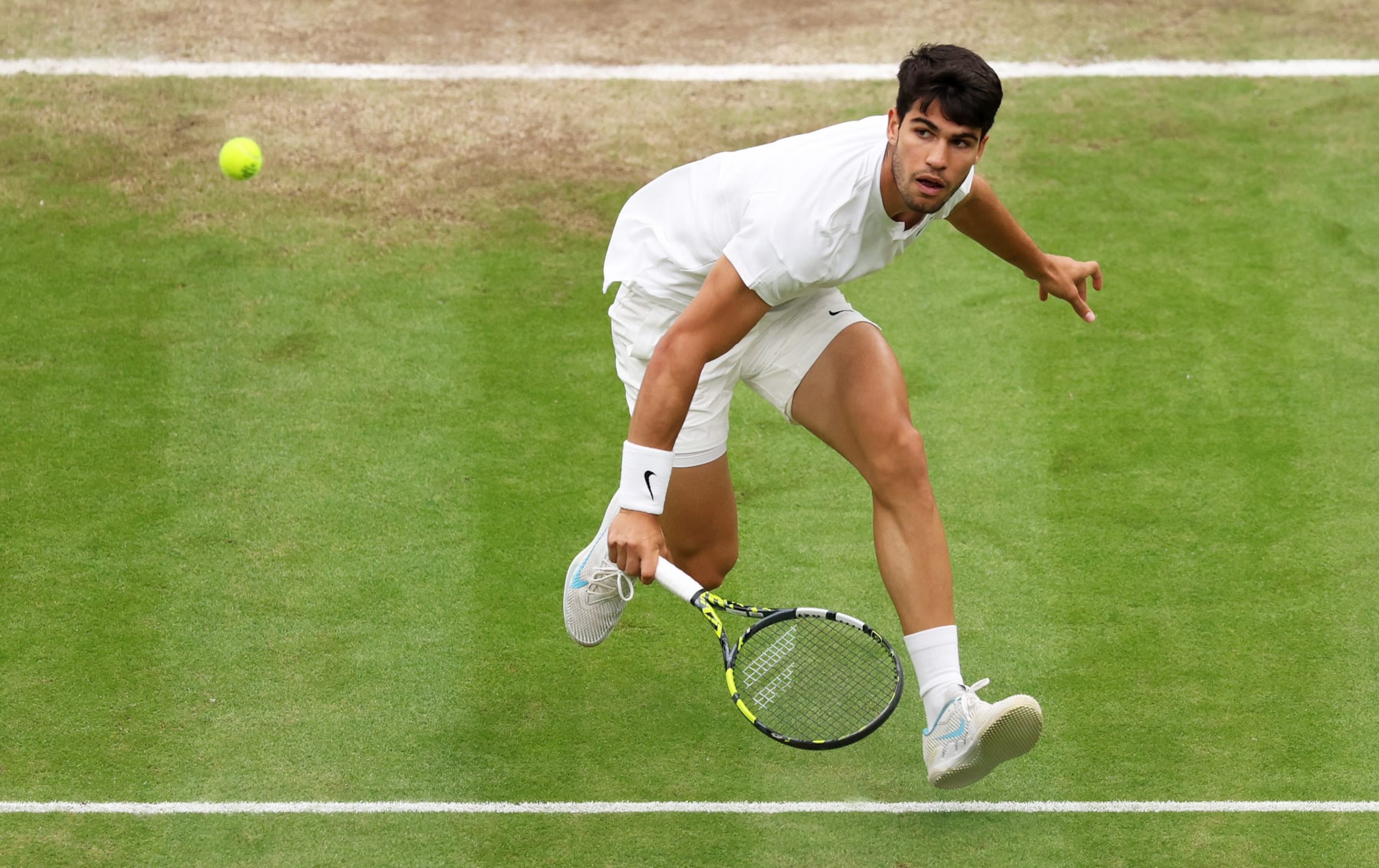 LONDON, ENGLAND - JULY 09: Carlos Alcaraz of Spain plays a backhand volley against Tommy Paul of United States in the Gentlemen's Singles Quarter Final match during day nine of The Championships Wimbledon 2024 at All England Lawn Tennis and Croquet Club on July 09, 2024 in London, England. (Photo by Clive Brunskill/Getty Images)