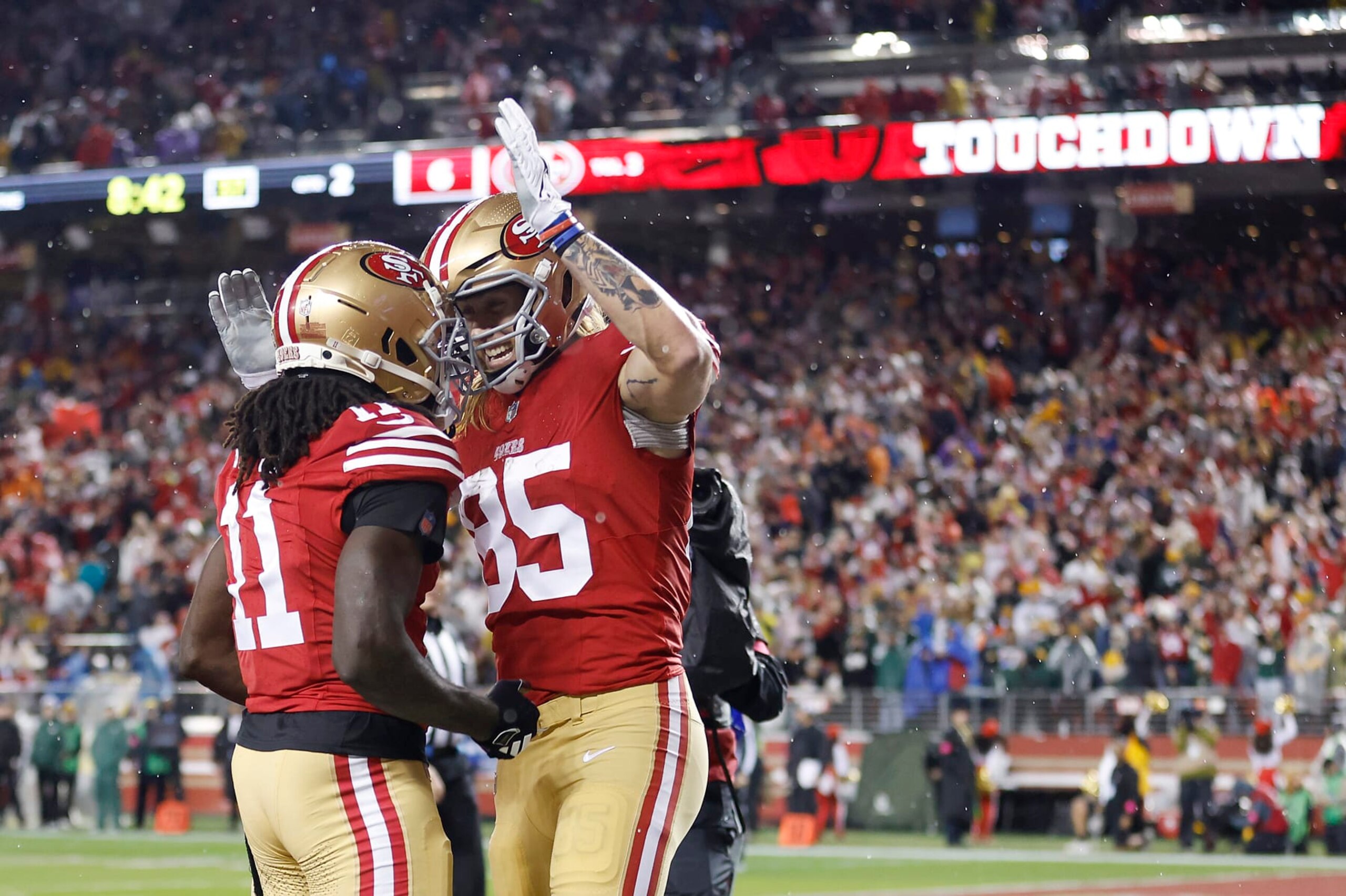 SANTA CLARA, CALIFORNIA - JANUARY 20: George Kittle #85 of the San Francisco 49ers celebrates with Brandon Aiyuk #11 after scoring a 32-yard touchdown during the second quarter against the Green Bay Packers in the NFC Divisional Playoffs at Levi's Stadium on January 20, 2024 in Santa Clara, California. (Photo by Lachlan Cunningham/Getty Images)