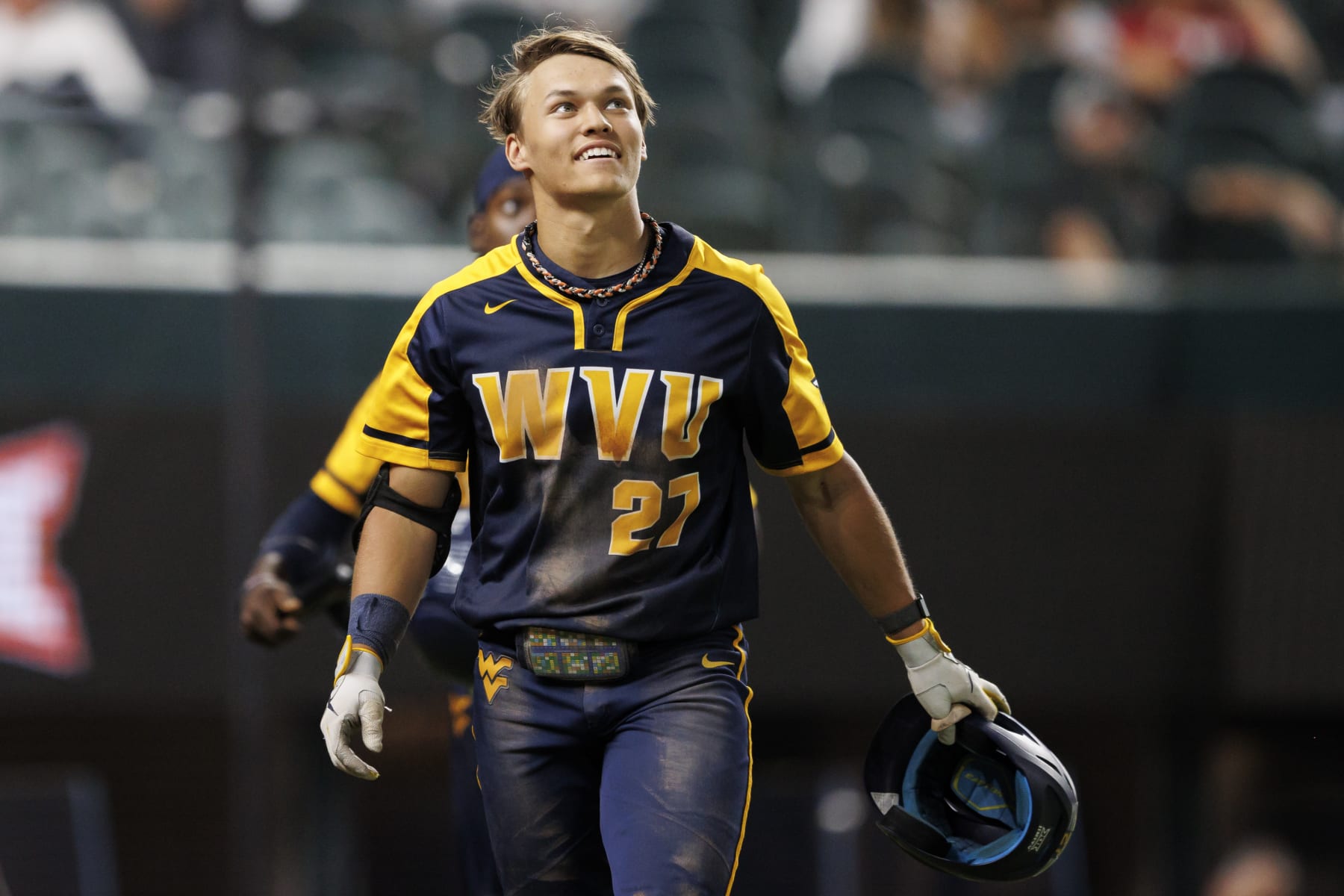 ARLINGTON, TX - MAY 25: JJ Wetherholt #27 of the West Virginia Mountaineers reacts after hitting a home run during a game against the Oklahoma Sooners at Globe Life Field on May 25, 2022 in Arlington, Texas. (Photo by Ben Ludeman/Texas Rangers/Getty Images)