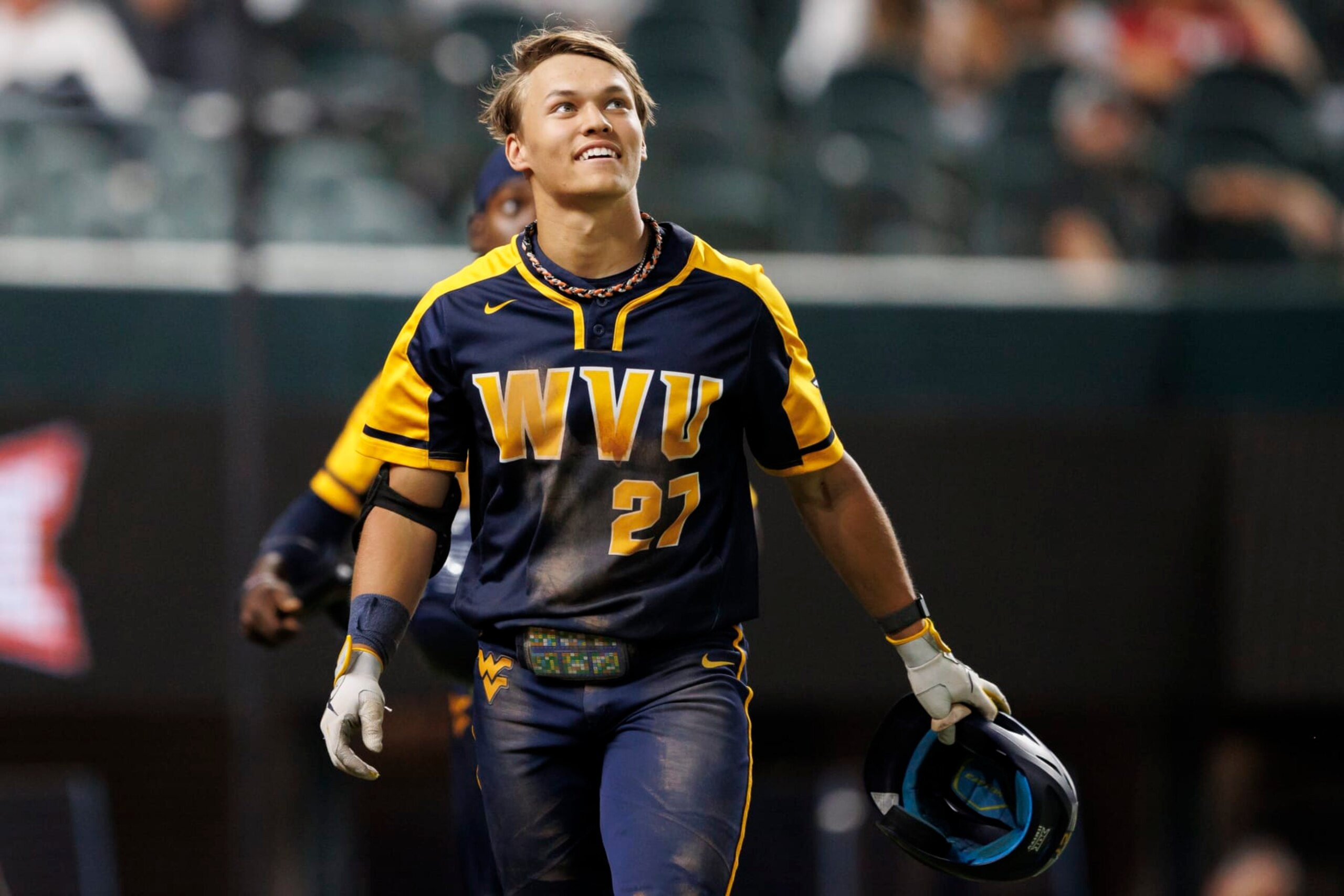ARLINGTON, TX - MAY 25: JJ Wetherholt #27 of the West Virginia Mountaineers reacts after hitting a home run during a game against the Oklahoma Sooners at Globe Life Field on May 25, 2022 in Arlington, Texas. (Photo by Ben Ludeman/Texas Rangers/Getty Images)