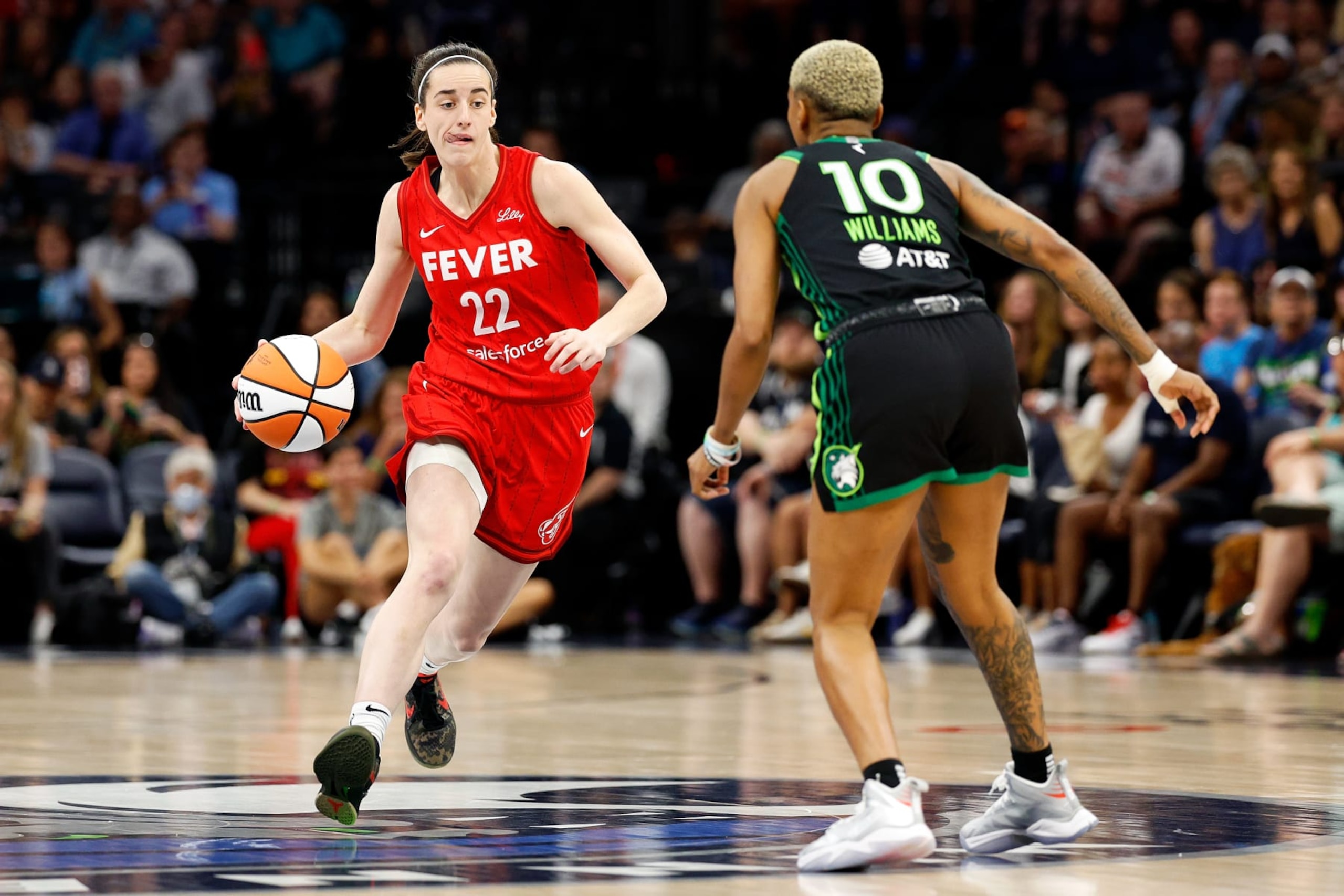 MINNEAPOLIS, MINNESOTA - JULY 14: Caitlin Clark #22 of the Indiana Fever dribbles the ball against Courtney Williams #10 of the Minnesota Lynx in the first quarter at Target Center on July 14, 2024 in Minneapolis, Minnesota. NOTE TO USER: User expressly acknowledges and agrees that, by downloading and or using this photograph, User is consenting to the terms and conditions of the Getty Images License Agreement. (Photo by David Berding/Getty Images)