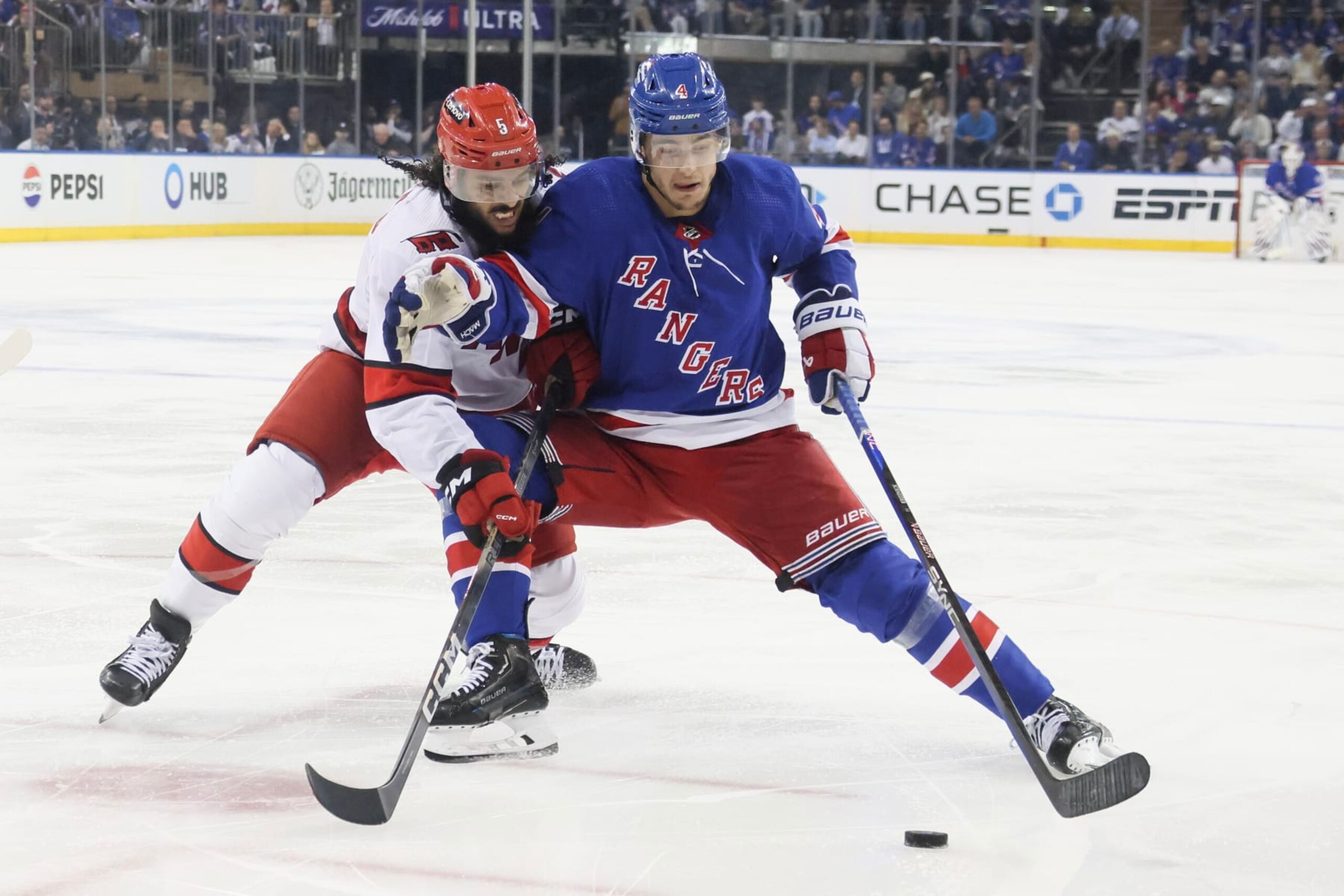 NEW YORK, NEW YORK - MAY 07: Jalen Chatfield #5 of the Carolina Hurricanes and Braden Schneider #4 of the New York Rangers fight for the puck during the second period in Game Two of the Second Round of the 2024 Stanley Cup Playoffs at Madison Square Garden on May 07, 2024 in New York City. (Photo by Bruce Bennett/Getty Images)