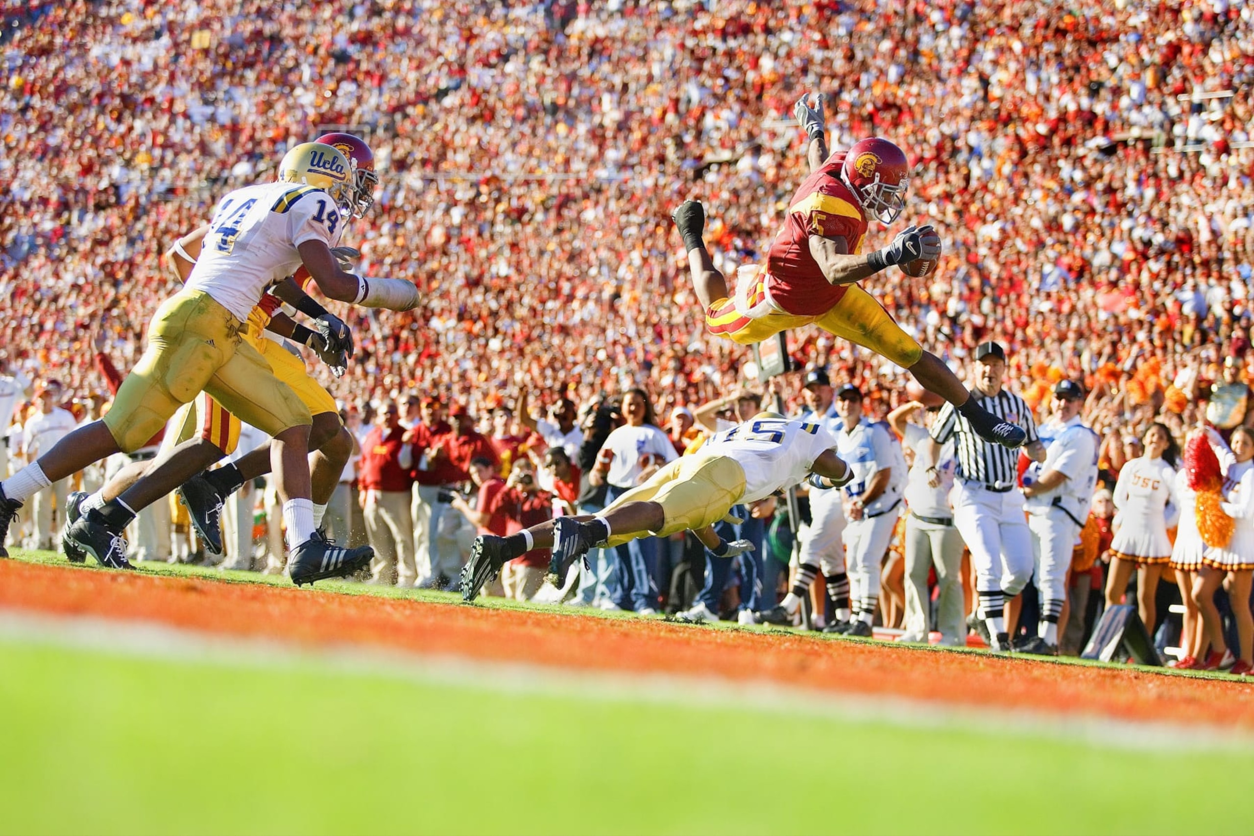 UNITED STATES - DECEMBER 03: College Football: USC Reggie Bush (5) in action, rushing and jumping over UCLA Marcus Cassel (15), Los Angeles, CA 12/3/2005 (Photo by Peter Read Miller/Sports Illustrated via Getty Images) (SetNumber: X74736 TK1) UNITED STATES - DECEMBER 03: College Football: USC Reggie Bush (5) in action, rushing and jumping over UCLA Marcus Cassel (15), Los Angeles, CA 12/3/2005 (Photo by Peter Read Miller/Sports Illustrated via Getty Images) (SetNumber: X74736 TK1)