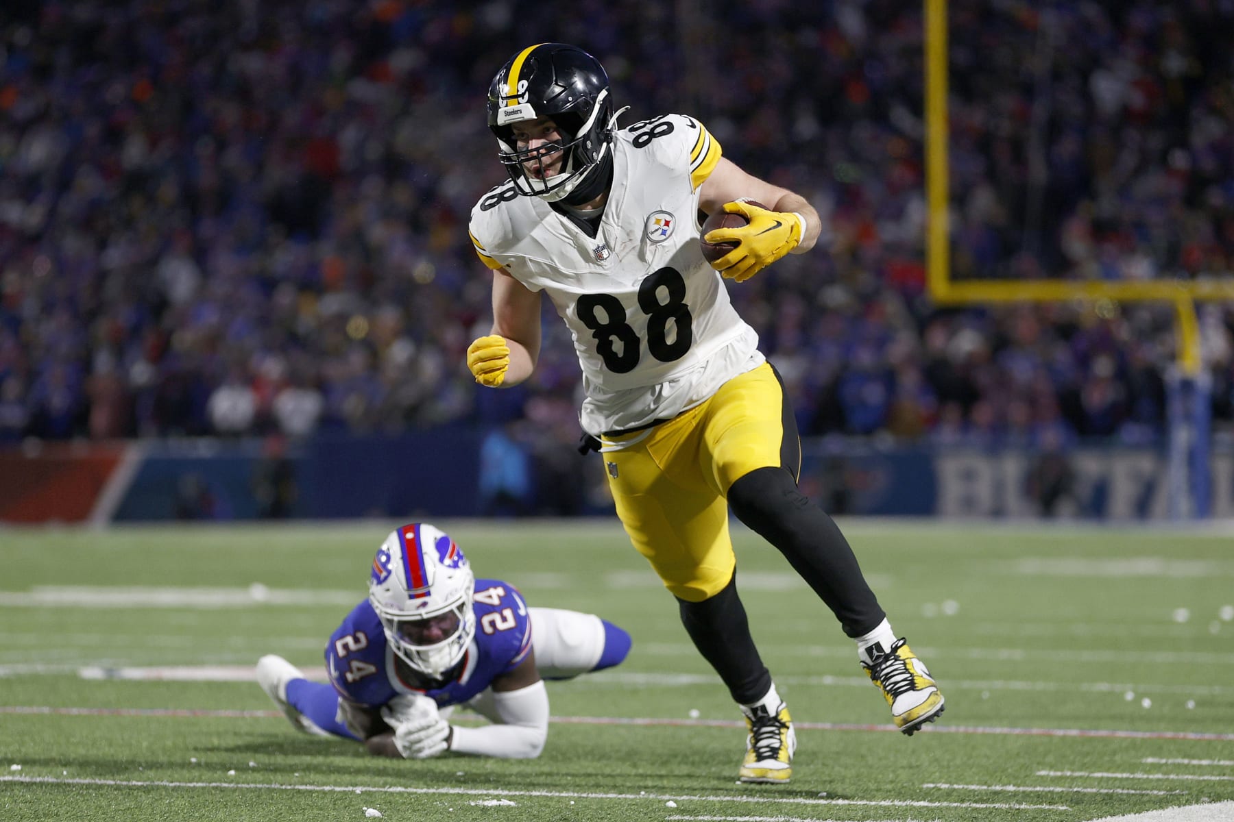ORCHARD PARK, NEW YORK - JANUARY 15: Pat Freiermuth #88 of the Pittsburgh Steelers carries the ball against Kaiir Elam #24 of the Buffalo Bills during the second quarter at Highmark Stadium on January 15, 2024 in Orchard Park, New York. (Photo by Sarah Stier/Getty Images)