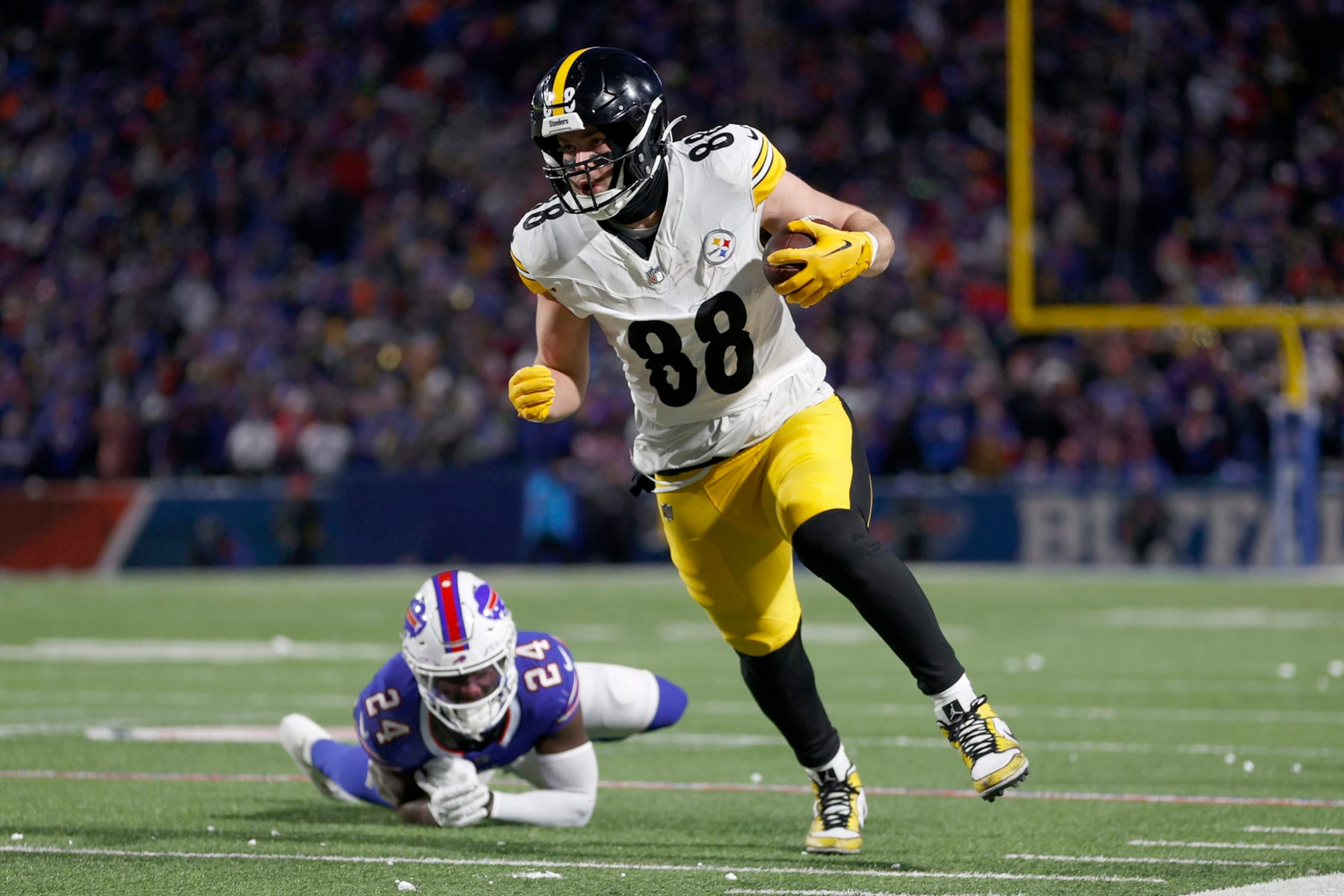 ORCHARD PARK, NEW YORK - JANUARY 15: Pat Freiermuth #88 of the Pittsburgh Steelers carries the ball against Kaiir Elam #24 of the Buffalo Bills during the second quarter at Highmark Stadium on January 15, 2024 in Orchard Park, New York. (Photo by Sarah Stier/Getty Images)