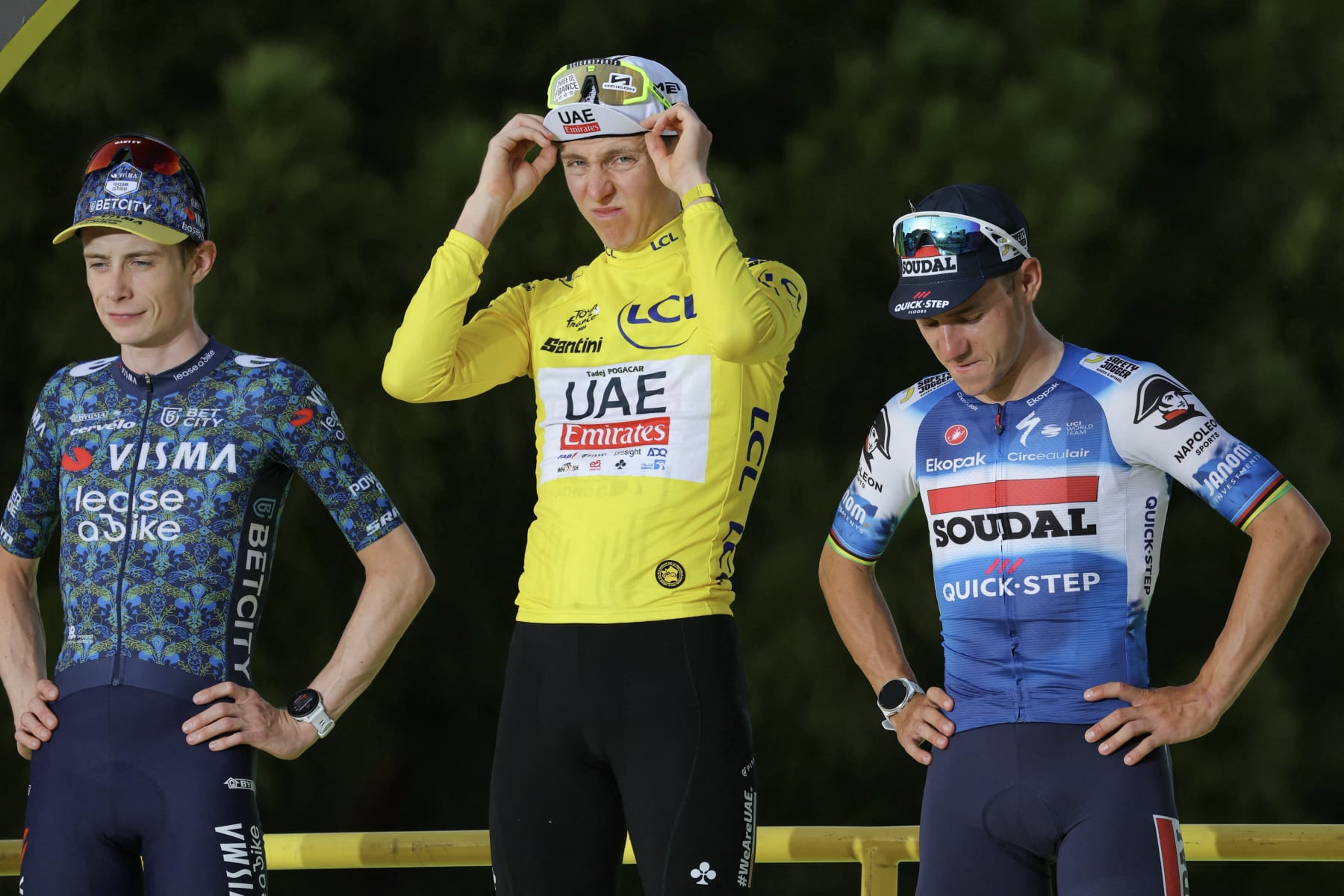 Overall winner UAE Team Emirates team's Slovenian rider Tadej Pogacar (C) celebrates on the podium , flanked by second-placed Team Visma - Lease a Bike team's Danish rider Jonas Vingegaard (L) and third-placed Soudal Quick-Step team's Belgian rider Remco Evenepoel (R) after the 21st and final stage of the 111th edition of the Tour de France cycling race, a 33,7 km individual time-trial between Monaco and Nice, on July 21, 2024. (Photo by Thomas SAMSON / AFP) (Photo by THOMAS SAMSON/AFP via Getty Images)
