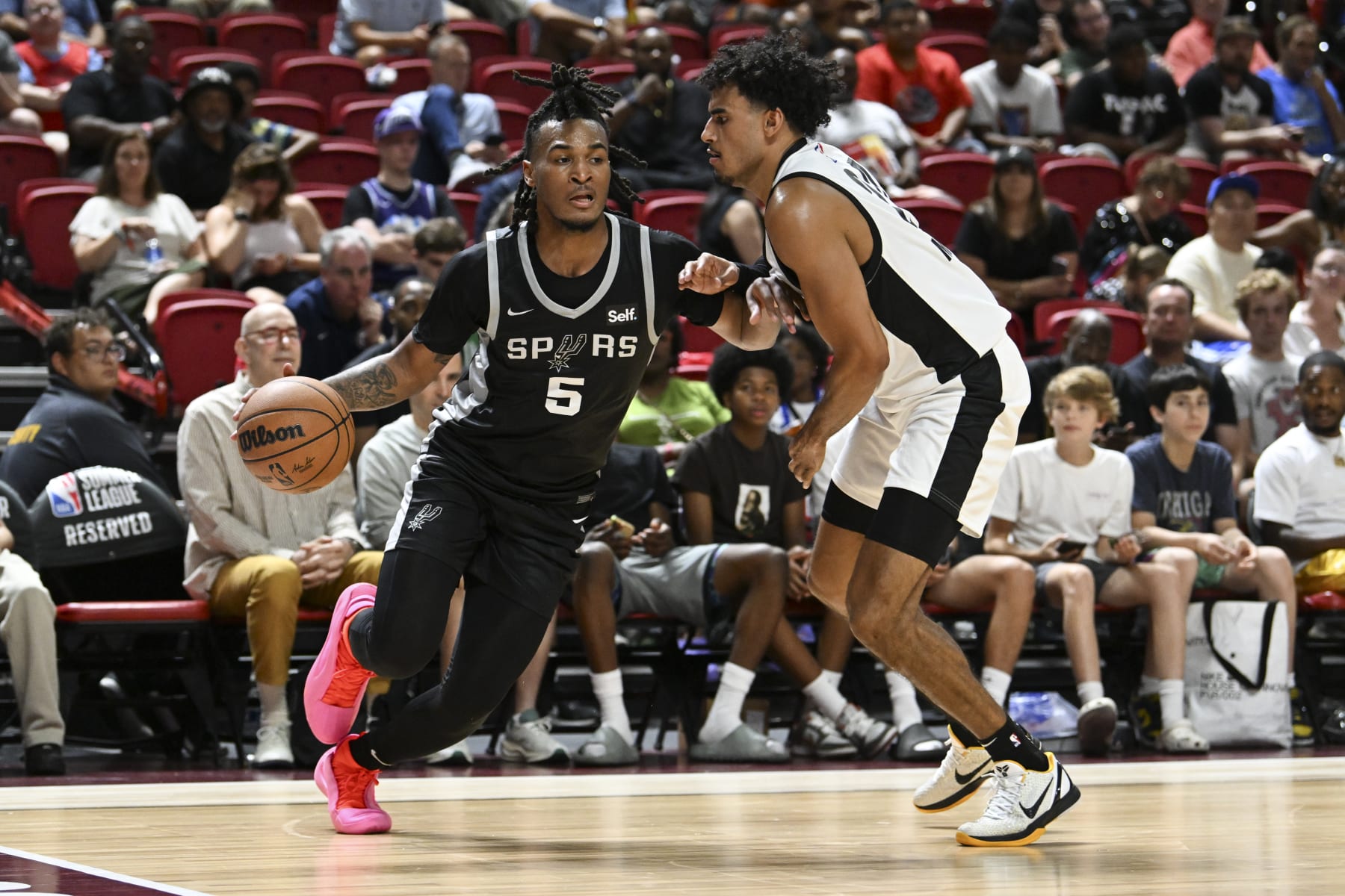 LAS VEGAS, NEVADA - JULY 13: Stephon Castle #5 of the San Antonio Spurs drives past Justin Minaya #24 of the Portland Trail Blazers in the second half of a 2024 NBA Summer League game at the Thomas & Mack Center on July 13, 2024 in Las Vegas, Nevada. The Spurs defeated the Trail Blazers 83-77. NOTE TO USER: User expressly acknowledges and agrees that, by downloading and or using this photograph, User is consenting to the terms and conditions of the Getty Images License Agreement. (Photo by Candice Ward/Getty Images)