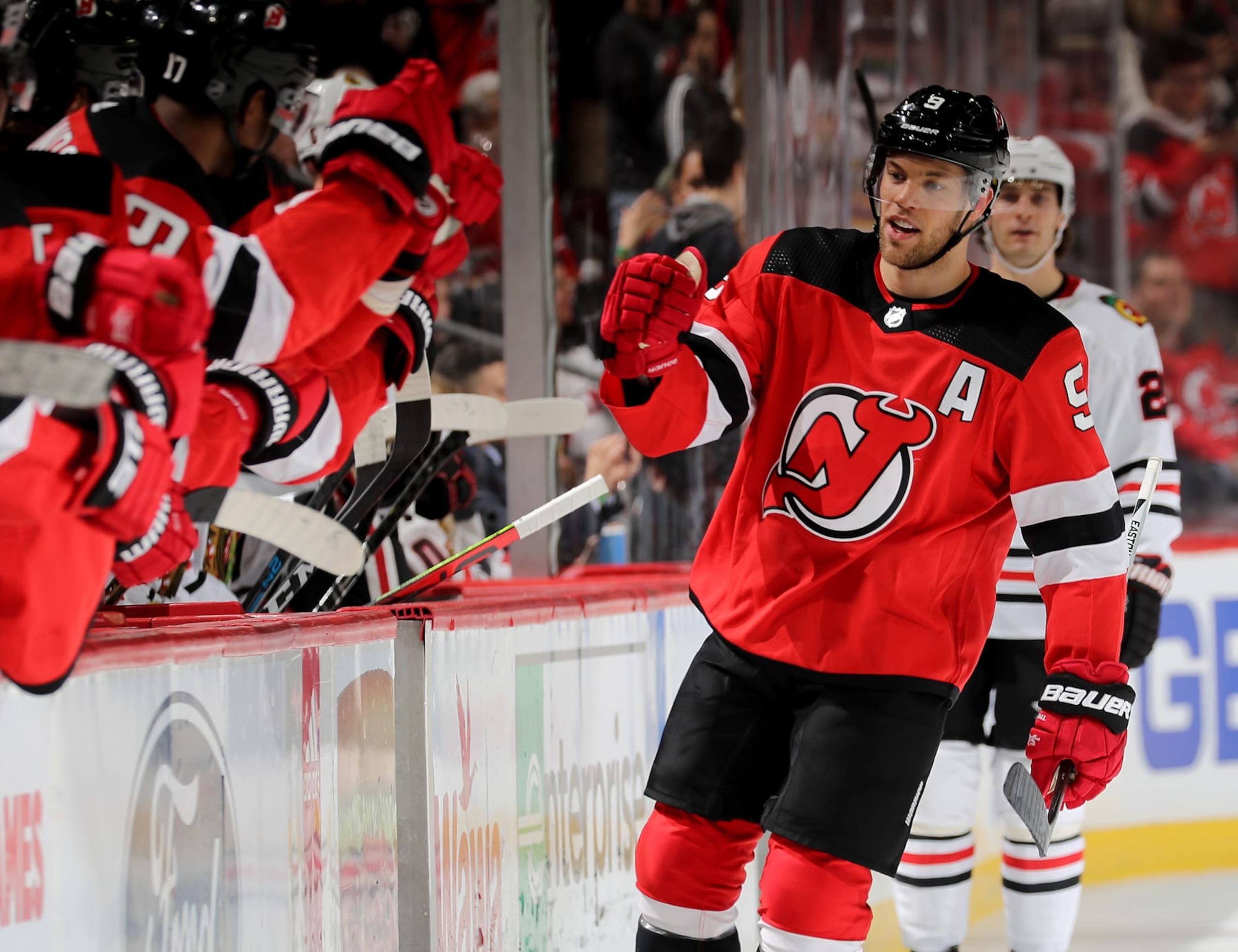 NEWARK, NEW JERSEY - DECEMBER 06:  Taylor Hall #9 of the New Jersey Devils celebrates his goal with teammates on the bench in the first period against the Chicago Blackhawks at Prudential Center on December 06, 2019 in Newark, New Jersey. (Photo by Elsa/Getty Images)