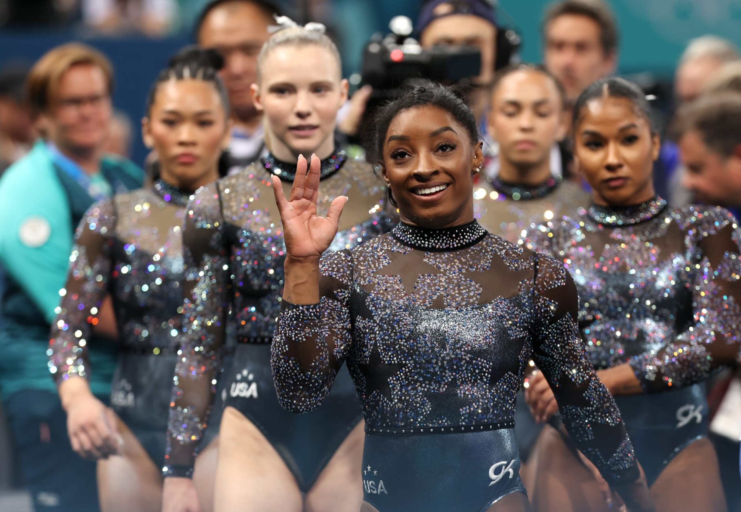 PARIS, FRANCE - JULY 28: Simone Biles of Team United States waves as she is joined by members of Team United States following Subdivision 2 during the Artistic Gymnastics Women's Qualification on day two of the Olympic Games Paris 2024 at Bercy Arena on July 28, 2024 in Paris, France. (Photo by Ezra Shaw/Getty Images) PARIS, FRANCE - JULY 28: Simone Biles of Team United States waves as she is joined by members of Team United States following Subdivision 2 during the Artistic Gymnastics Women's Qualification on day two of the Olympic Games Paris 2024 at Bercy Arena on July 28, 2024 in Paris, France. (Photo by Ezra Shaw/Getty Images)