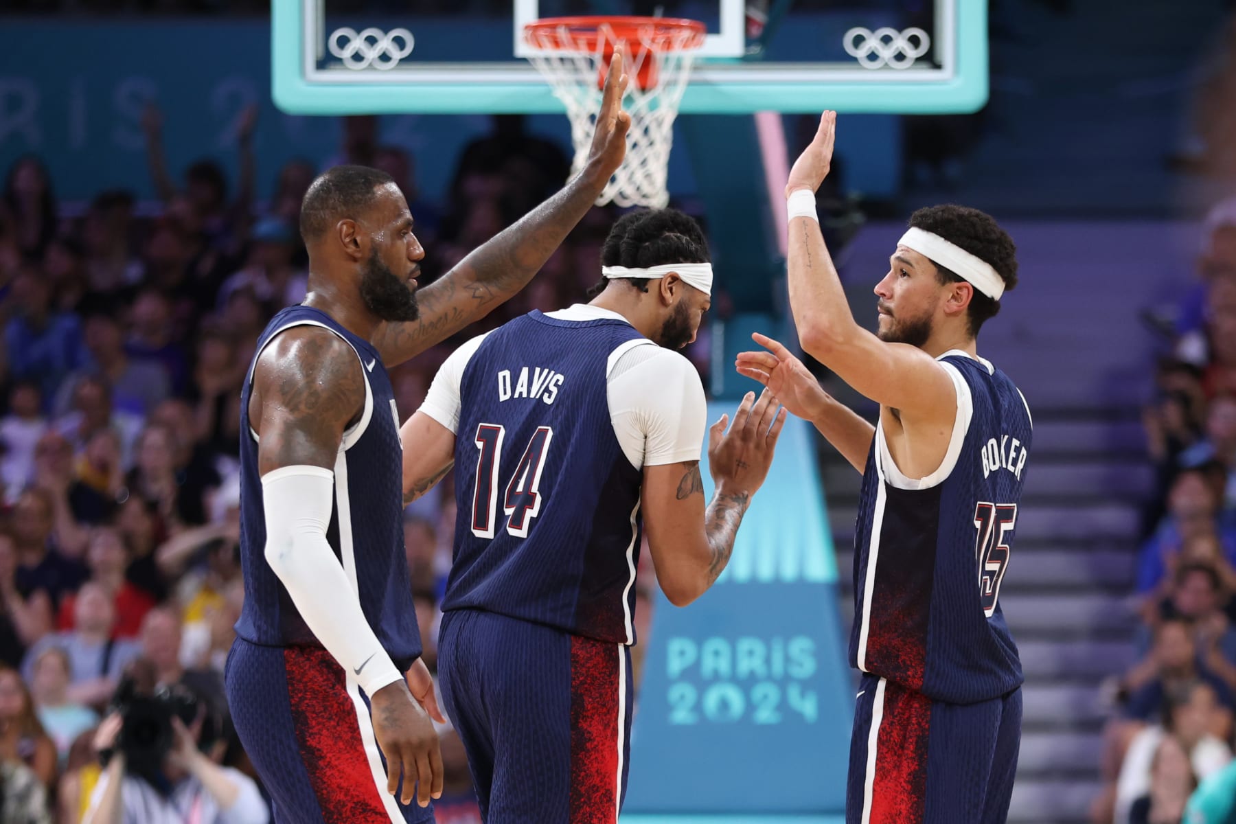 LILLE, FRANCE - JULY 28: Lebron James #6 high fives Devin Booker #15 of Team United States during the second half of the Men's Group Phase - Group C game between Serbia and the United States on day two of the Olympic Games Paris 2024 at Stade Pierre Mauroy on July 28, 2024 in Lille, France. (Photo by Gregory Shamus/Getty Images)