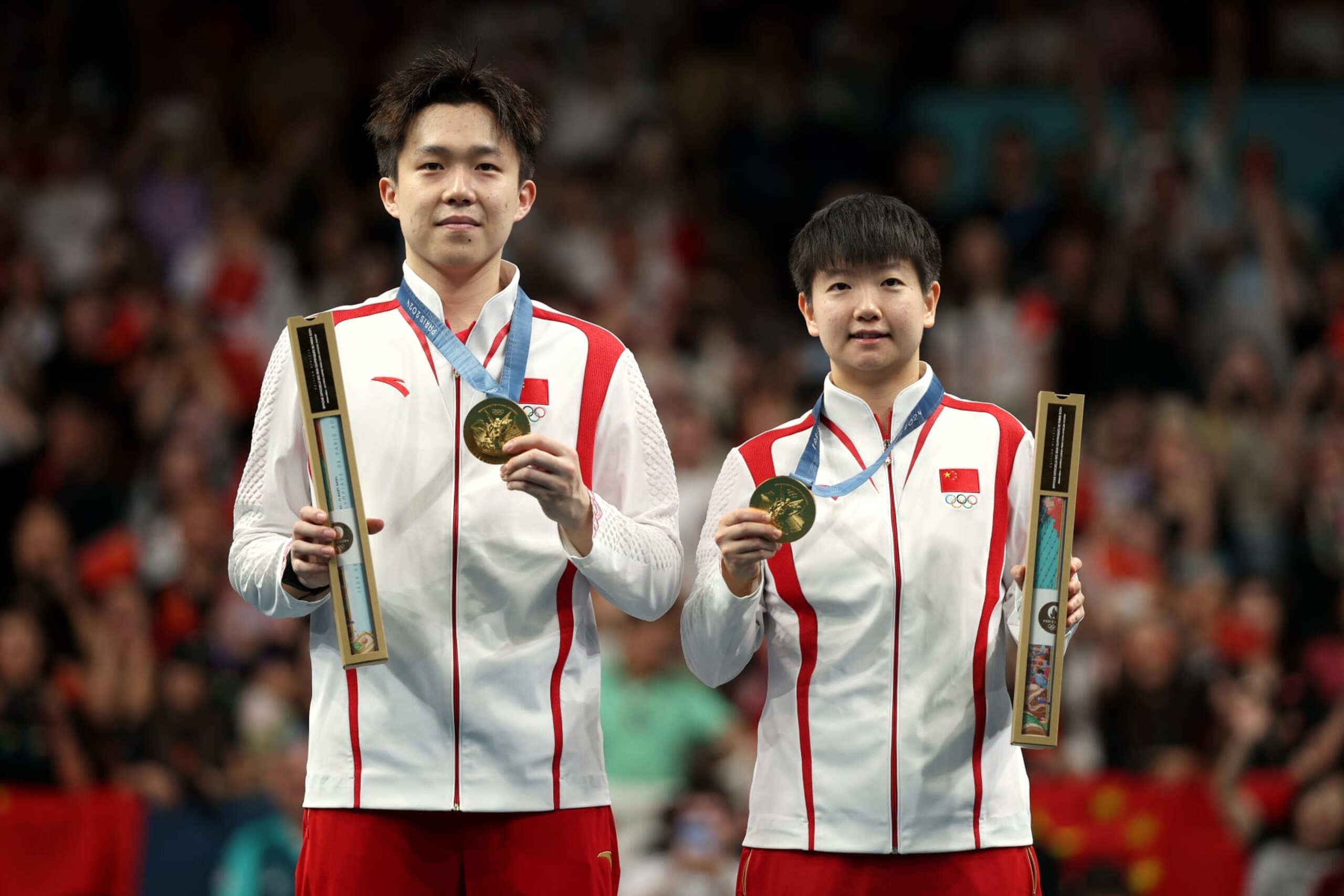 PARIS, FRANCE - JULY 30: Chuqin Wang and Yingsha Sun of Team People’s Republic of China pose for a photo with their gold medals following victory in the Mixed Doubles, Gold Medal match between Team People’s Republic of China and Team Democratic People’s Republic of Korea on day four of the Olympic Games Paris 2024 at South Paris Arena on July 30, 2024 in Paris, France. (Photo by Jared C. Tilton/Getty Images)