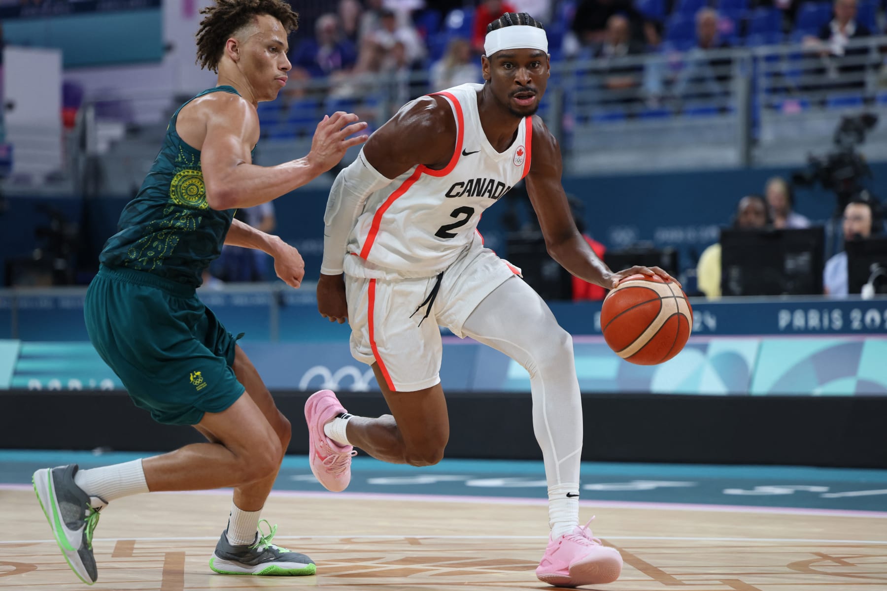 Canada's #02 Shai Gilgeous-Alexander outflanks Australia's #01 Dyson Daniels in the men's preliminary round group A basketball match between Canada and Australia during the Paris 2024 Olympic Games at the Pierre-Mauroy stadium in Villeneuve-d'Ascq, northern France, on July 30, 2024. (Photo by Thomas COEX / AFP) (Photo by THOMAS COEX/AFP via Getty Images)