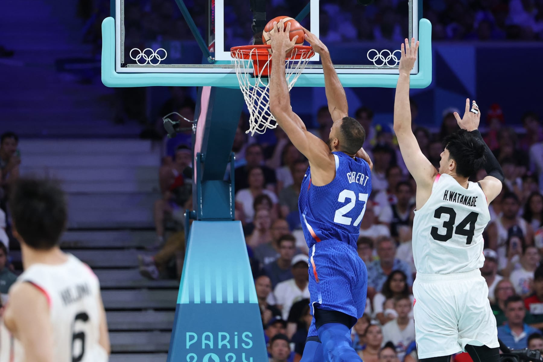 France's #27 Rudy Gobert dunks the ball past Japan's #34 Hugh Watanabe in the men's preliminary round group B basketball match between Japan and France during the Paris 2024 Olympic Games at the Pierre-Mauroy stadium in Villeneuve-d'Ascq, northern France, on July 30, 2024. (Photo by Thomas COEX / AFP) (Photo by THOMAS COEX/AFP via Getty Images)