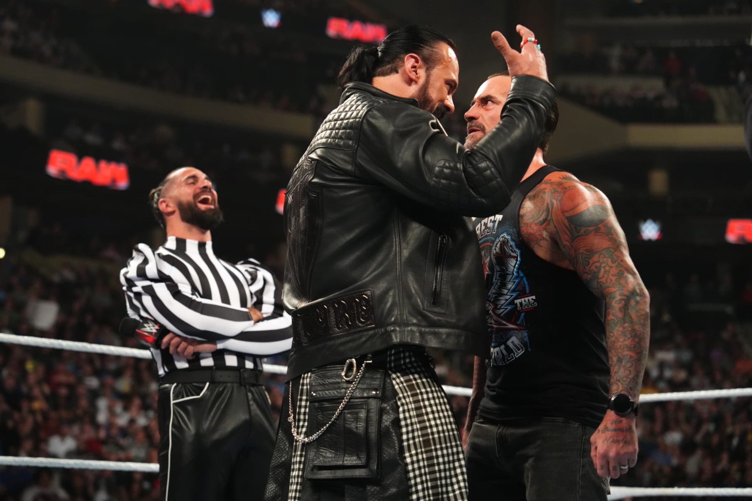 ST PAUL, MINNESOTA - JULY 29: Drew McIntyre (C) faces off in the ring with CM Punk as Seth Rollins (L) laughs during WWE's Monday Night RAW at Xcel Energy Center on July 29, 2024 in St Paul, Minnesota.  (Photo by WWE/Getty Images)